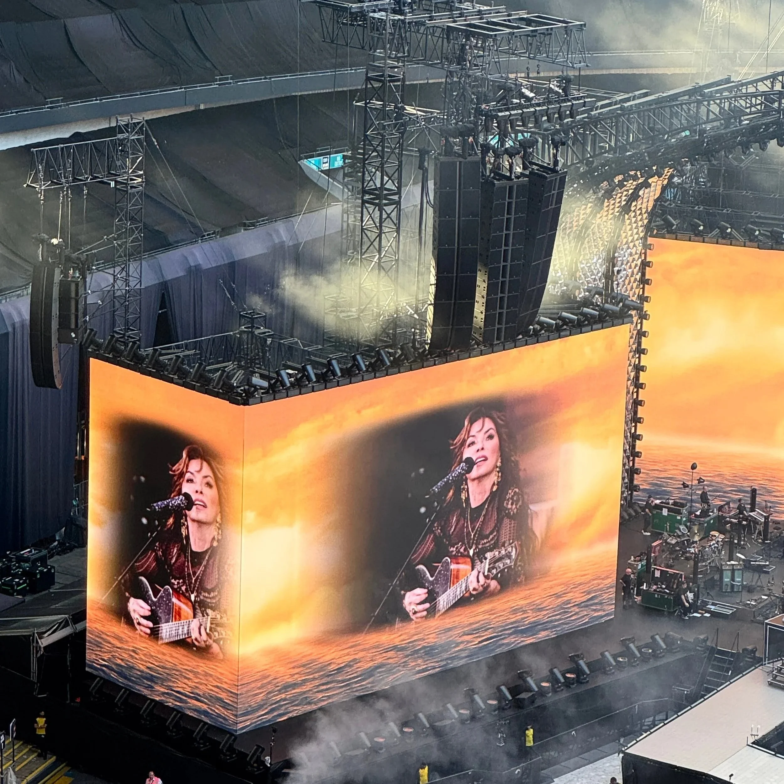 Shania Twain performing on stage during Harry Styles' "Together Together" tour, with a large screen in the background.