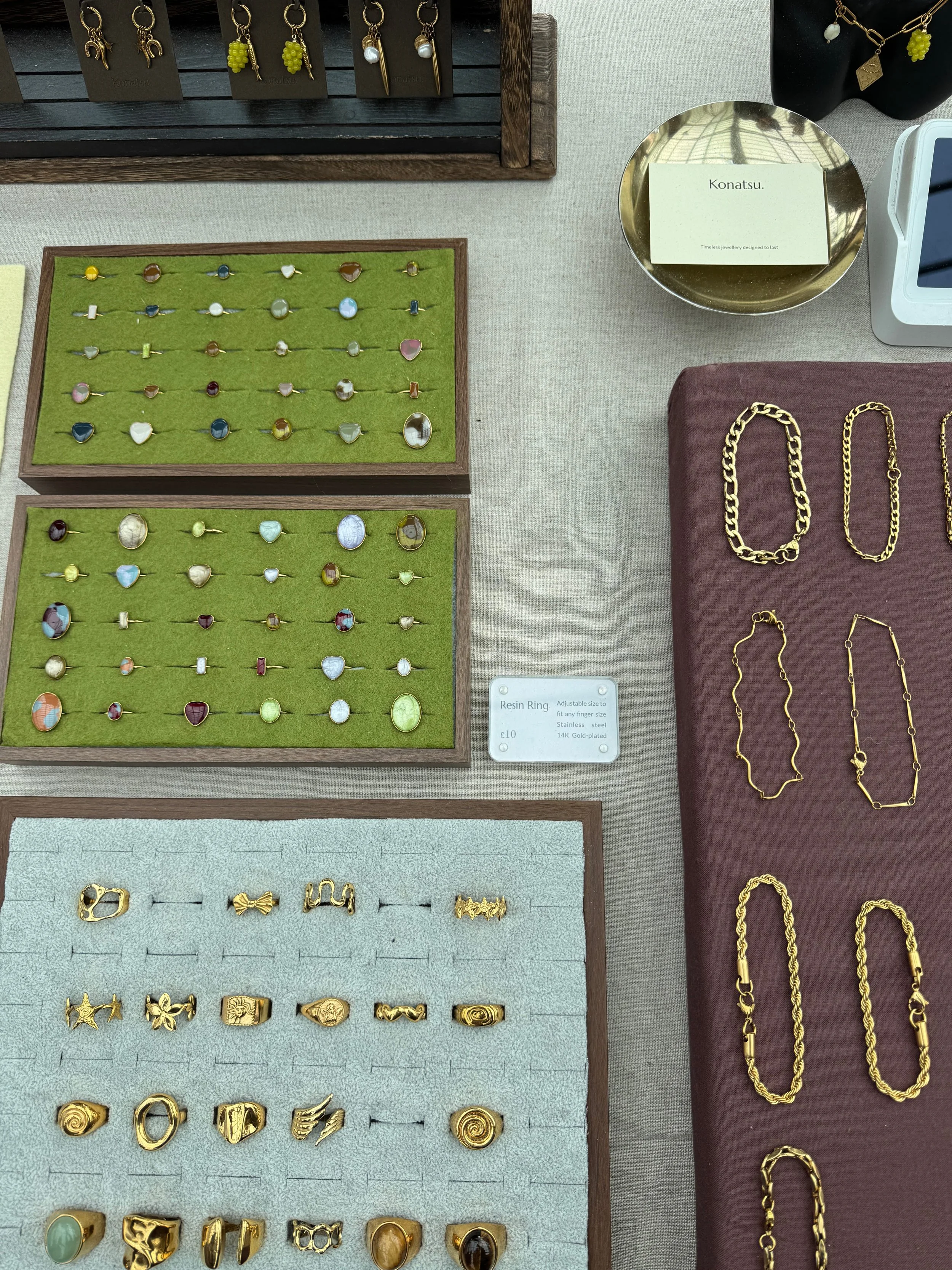 A table displaying an assortment of gold jewelry, including necklaces, bracelets, and rings, alongside decorative items.