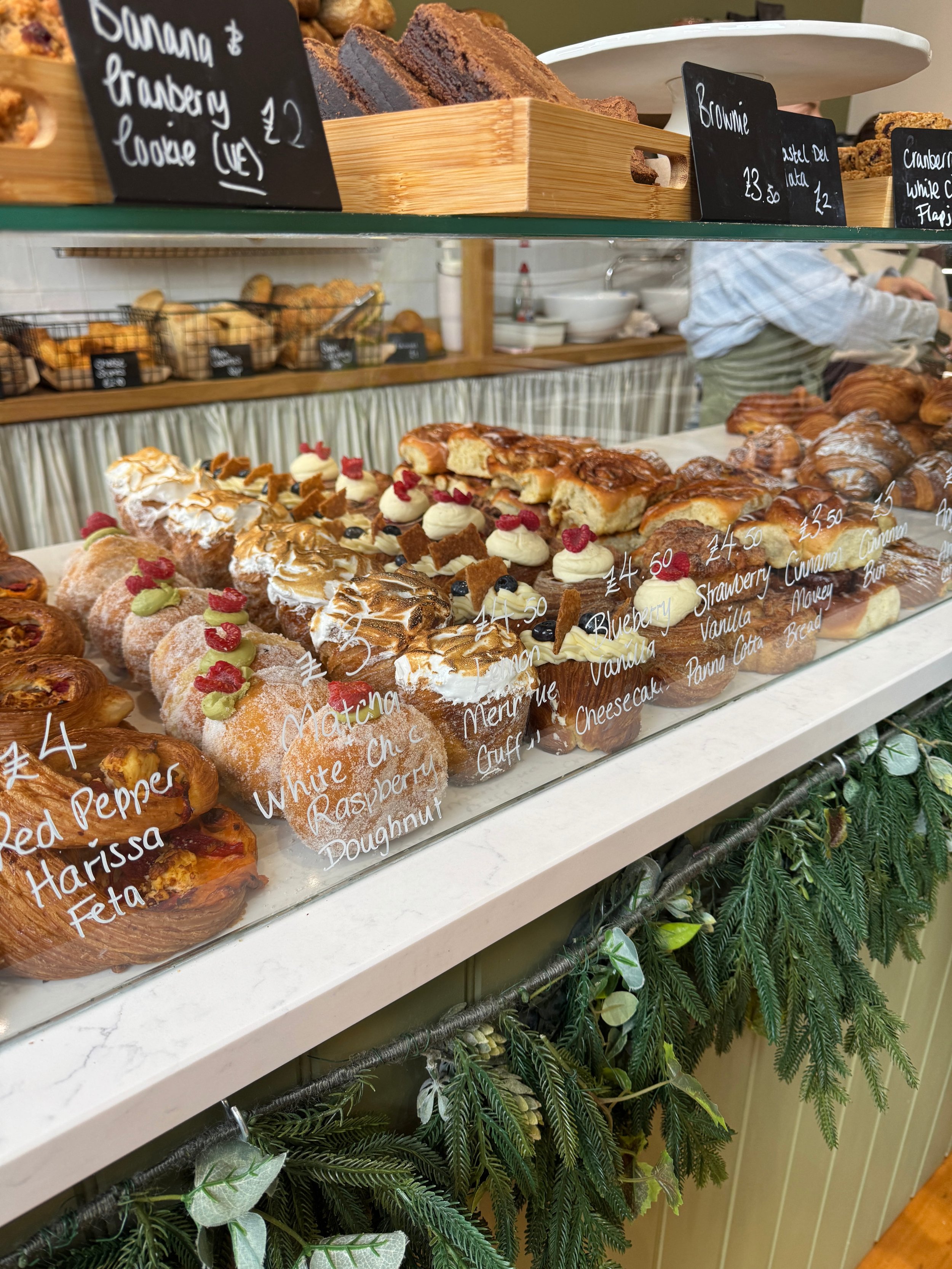 A vibrant bakery display showcasing an array of colorful pastries, including croissants, tarts, and donuts.