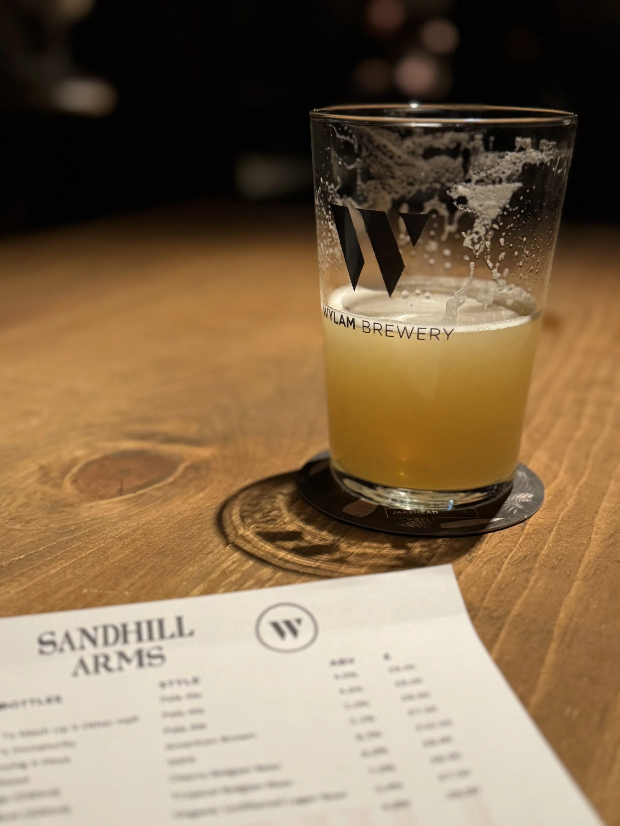 A pint of Wylam Brewery beer at Sandhill Arms in Newcastle, and a corner of the drinks menu in view.