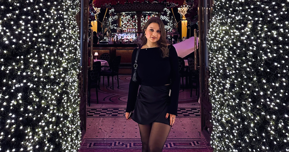 A woman standing in the Dome, Edinburgh, in front of twinkling Christmas decorations.