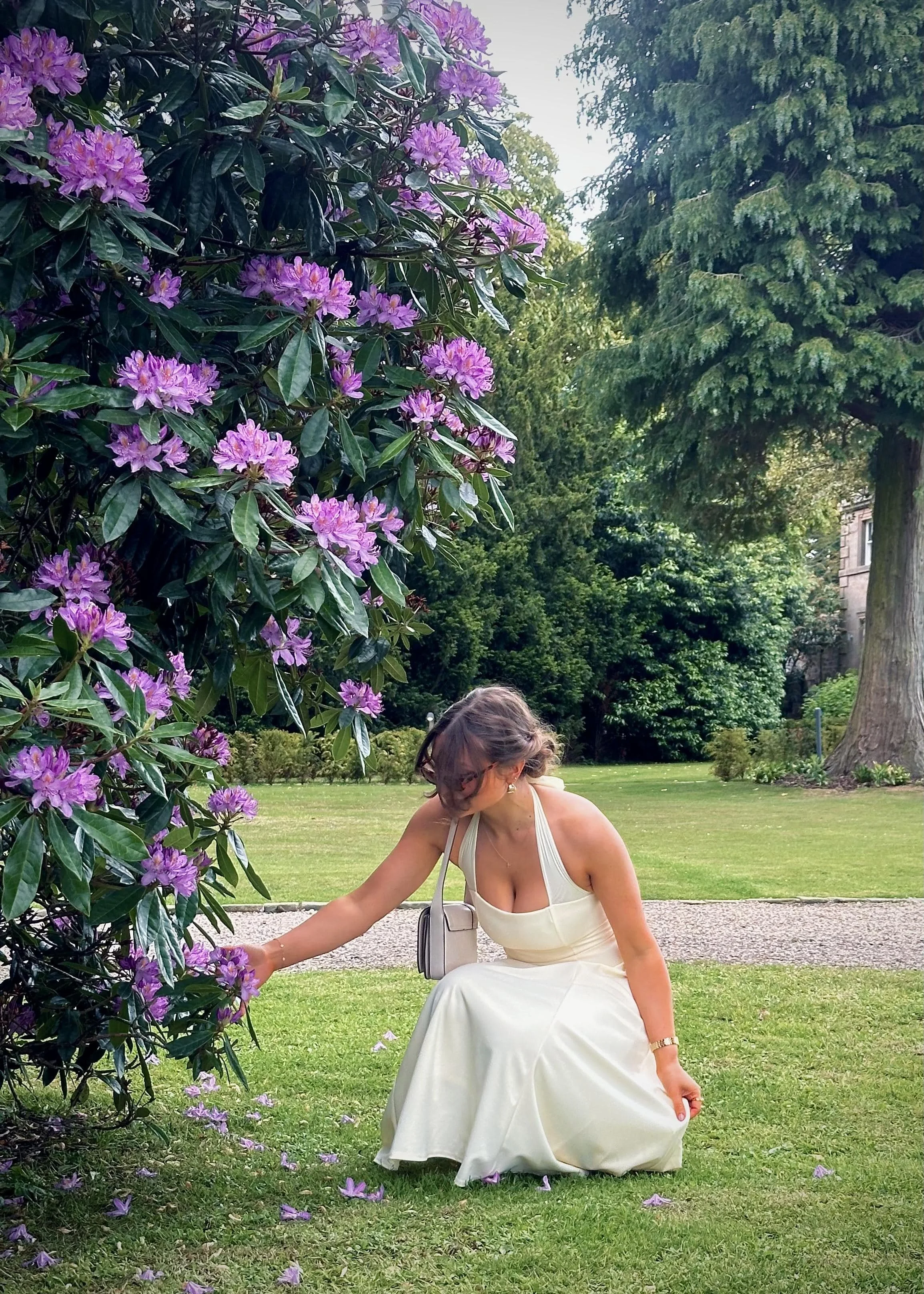 A woman in a yellow dress picking flowers