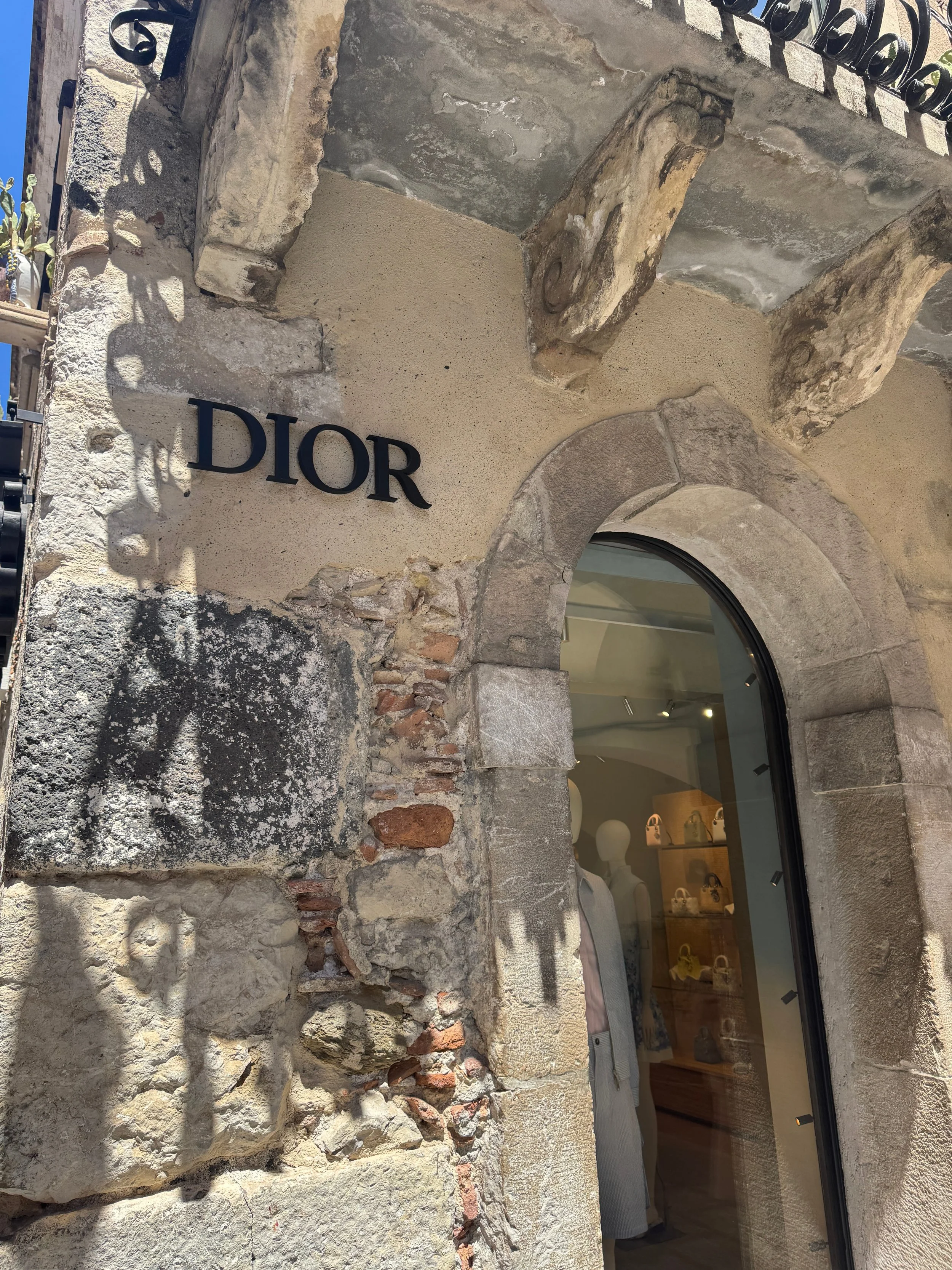 A stylish building featuring a prominent sign displaying the word "Dior" in elegant lettering.