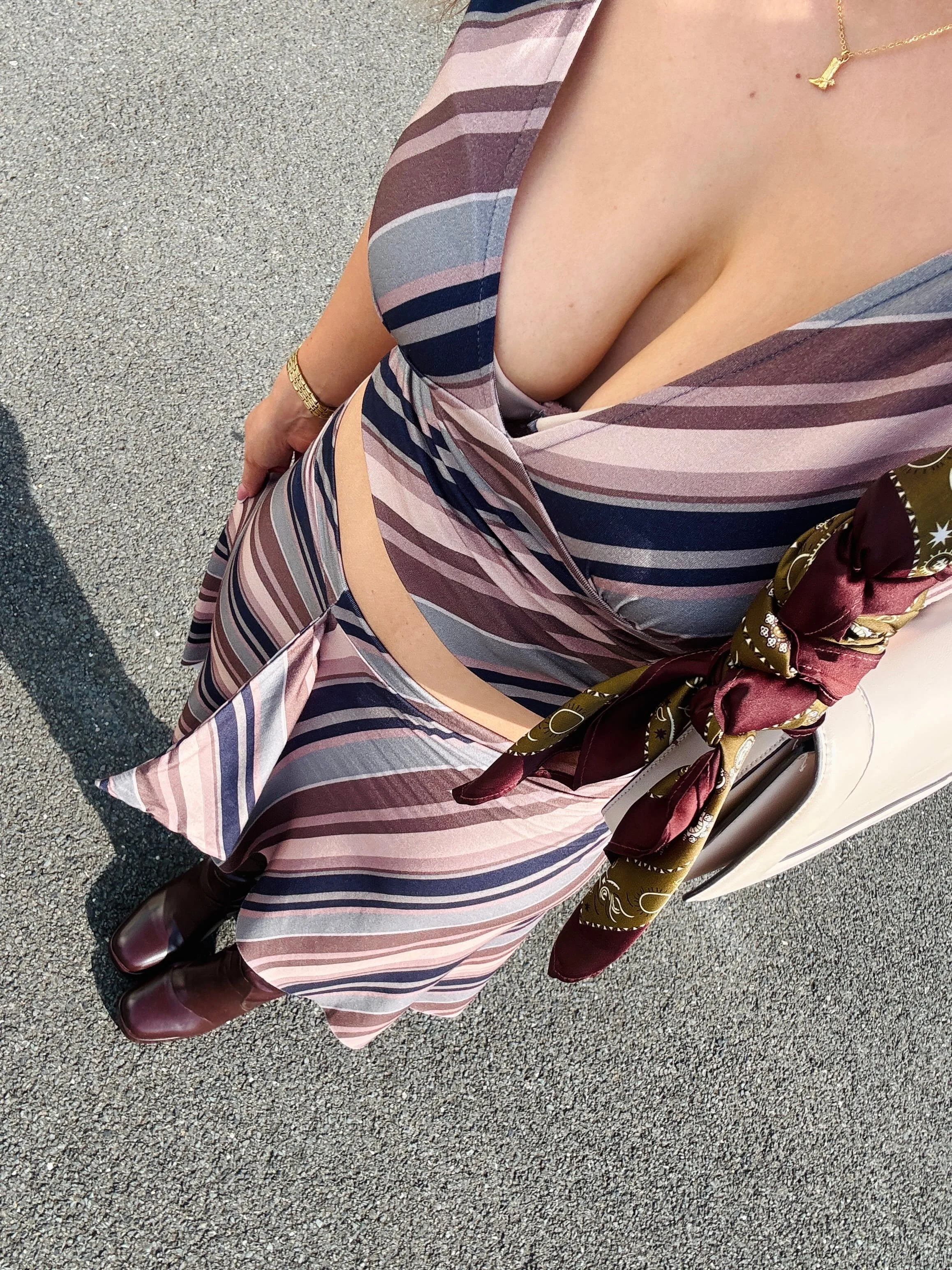 A woman in a vibrant striped two-piece paired with stylish boots.