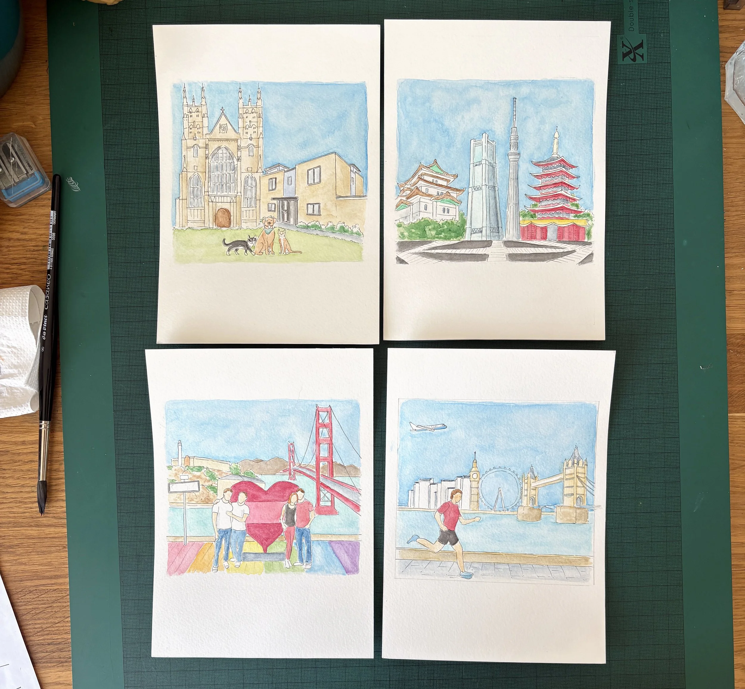 Photo showing the progress of four different scene illustrations, nearing the end of building up the watercolour, before I ink in the outlines and apply pencil.