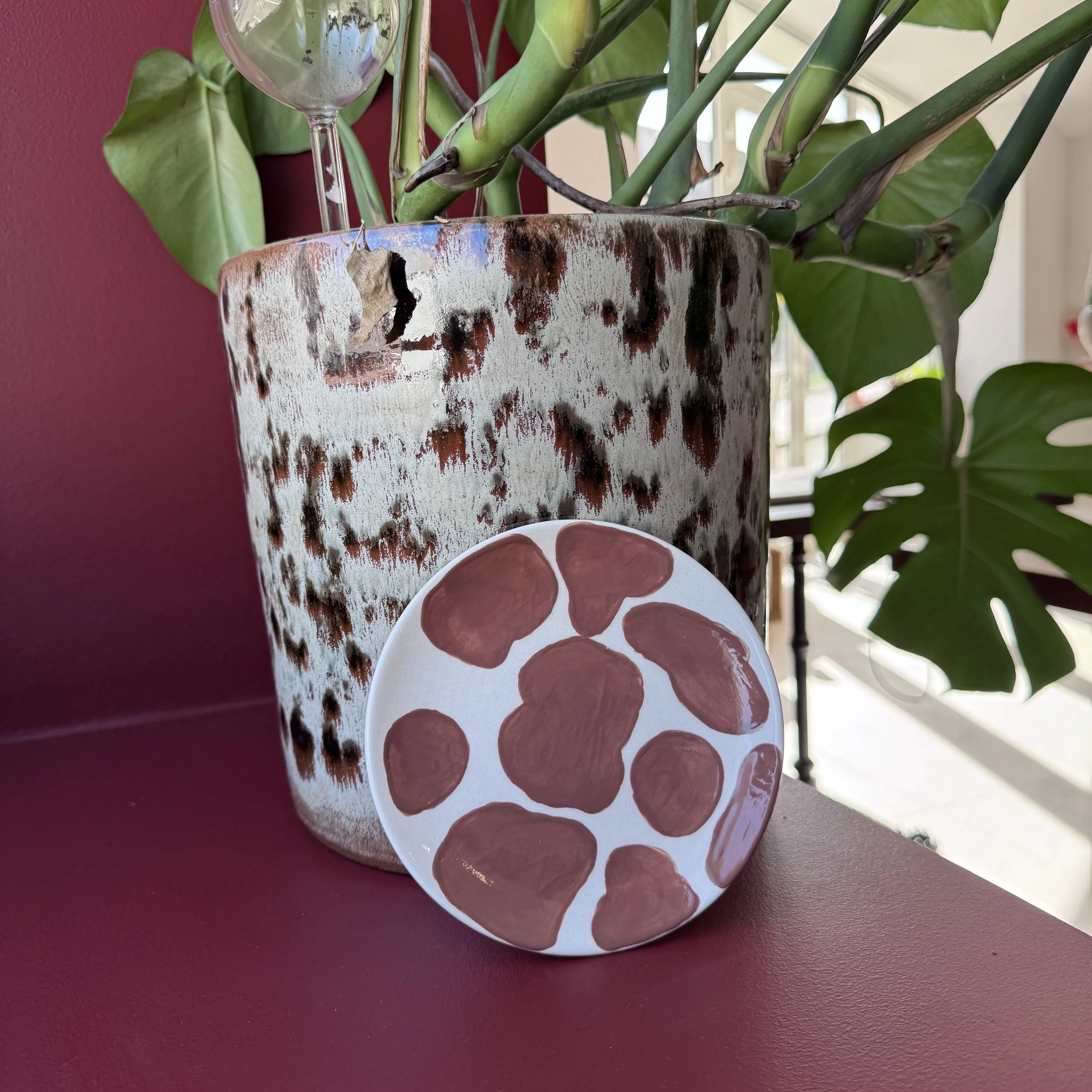 Un plat en forme de cœur blanc avec de petits cœurs rouges à l'intérieur, posé sur une surface en bois.