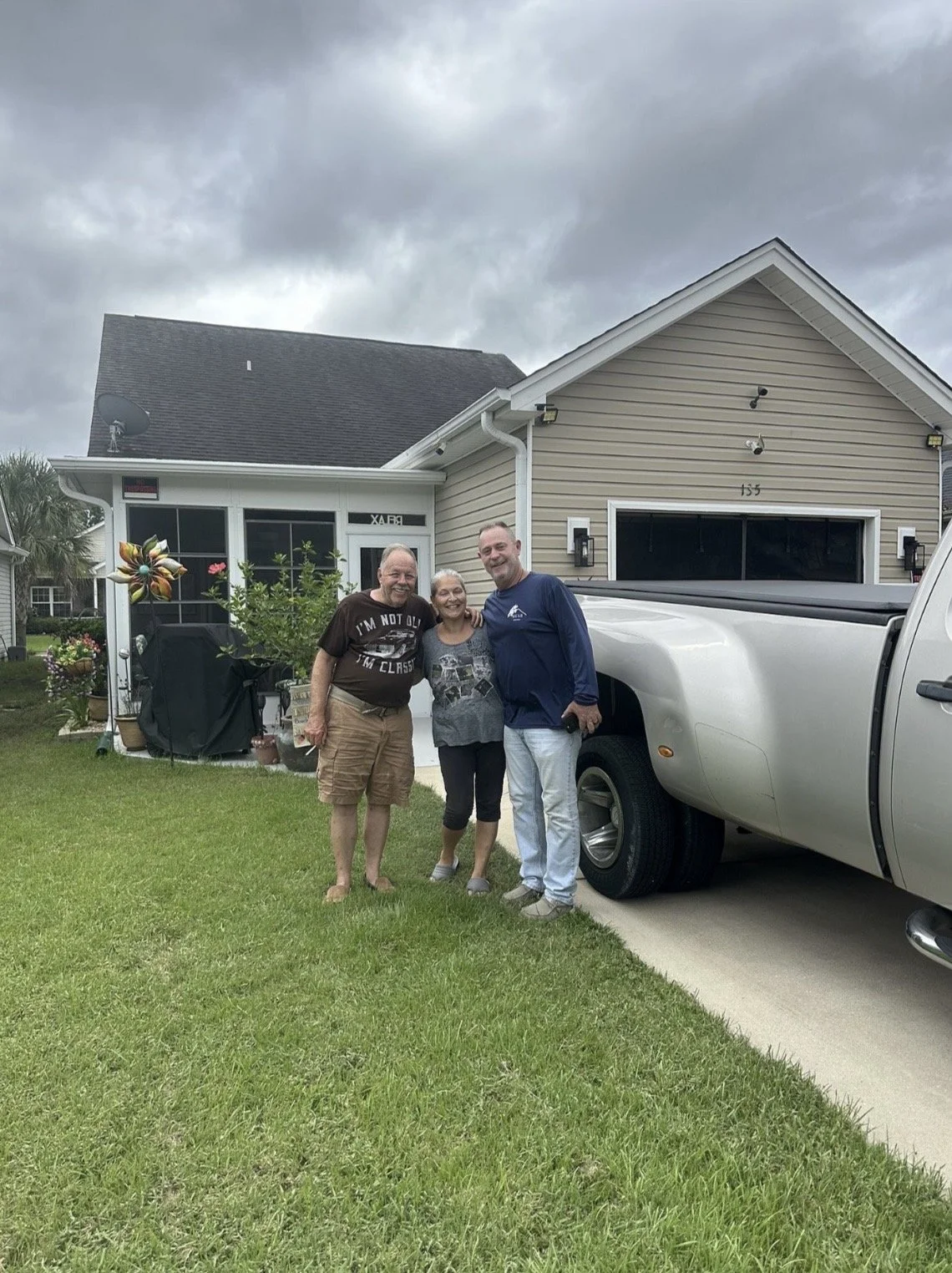 Bear Roofing LLC representative with happy homeowners following residential roof repair service
