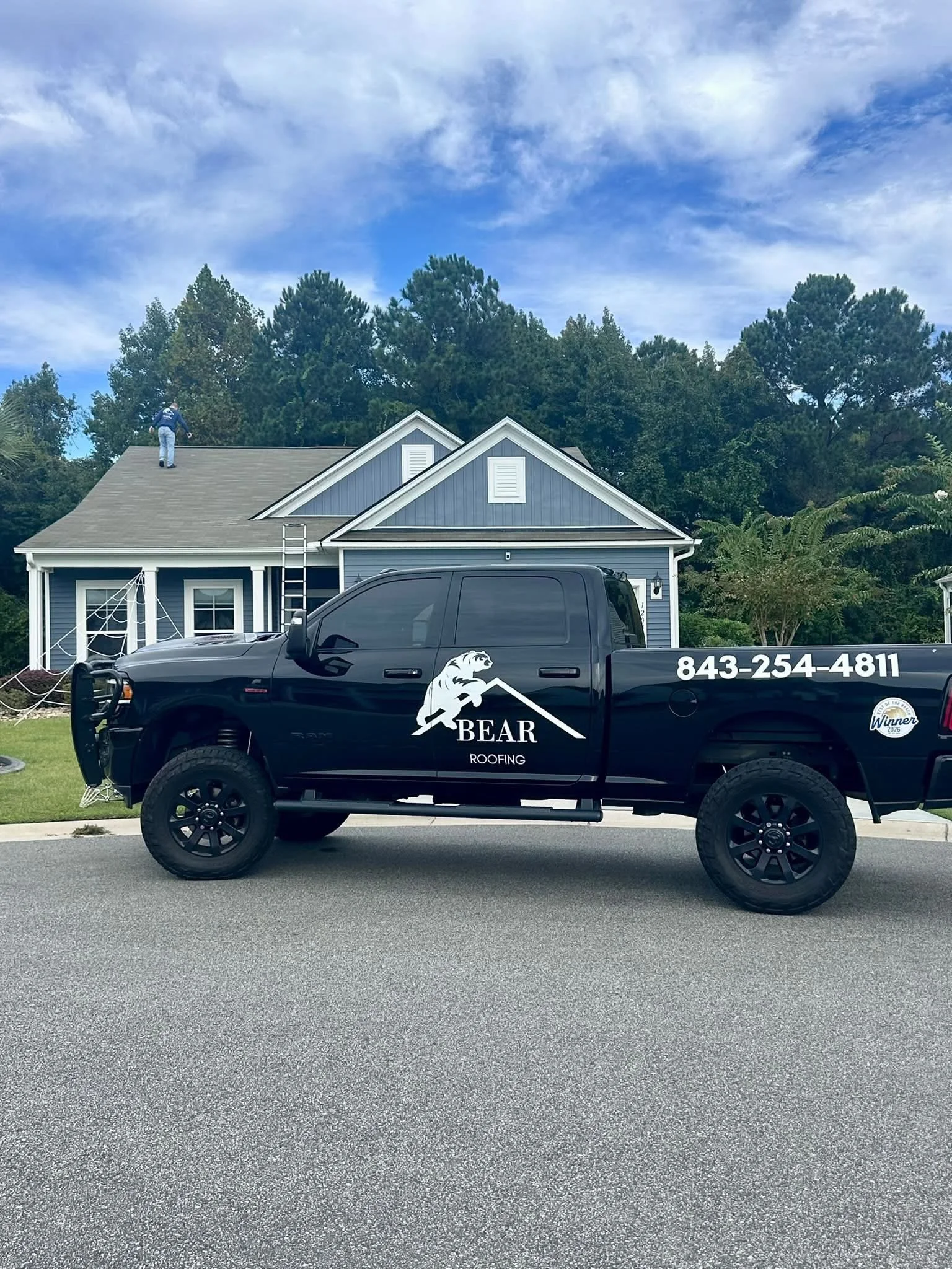 Bear Roofing LLC performing a residential roof inspection with company truck parked outside a home in South Carolina.
