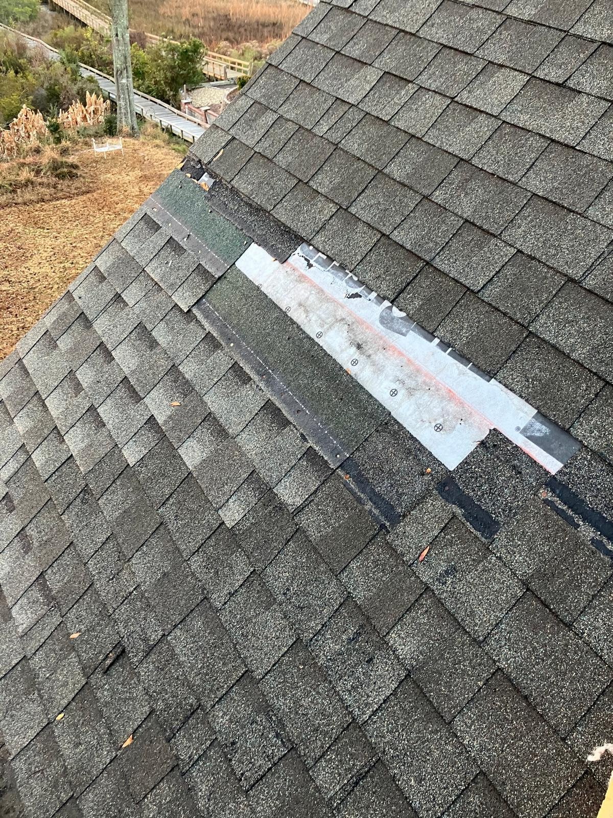 Damaged asphalt shingle roof with missing shingles and exposed underlayment in need of roof repair.