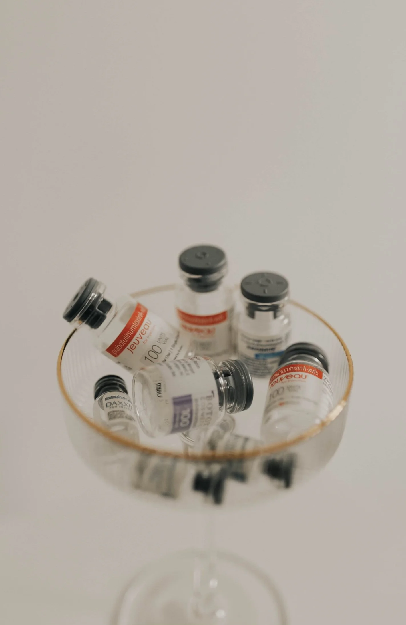 Botox, Jeuveau, Xeomin, and Daxxify neurotoxin vials arranged in a gold-rimmed dish at Golden Aesthetics