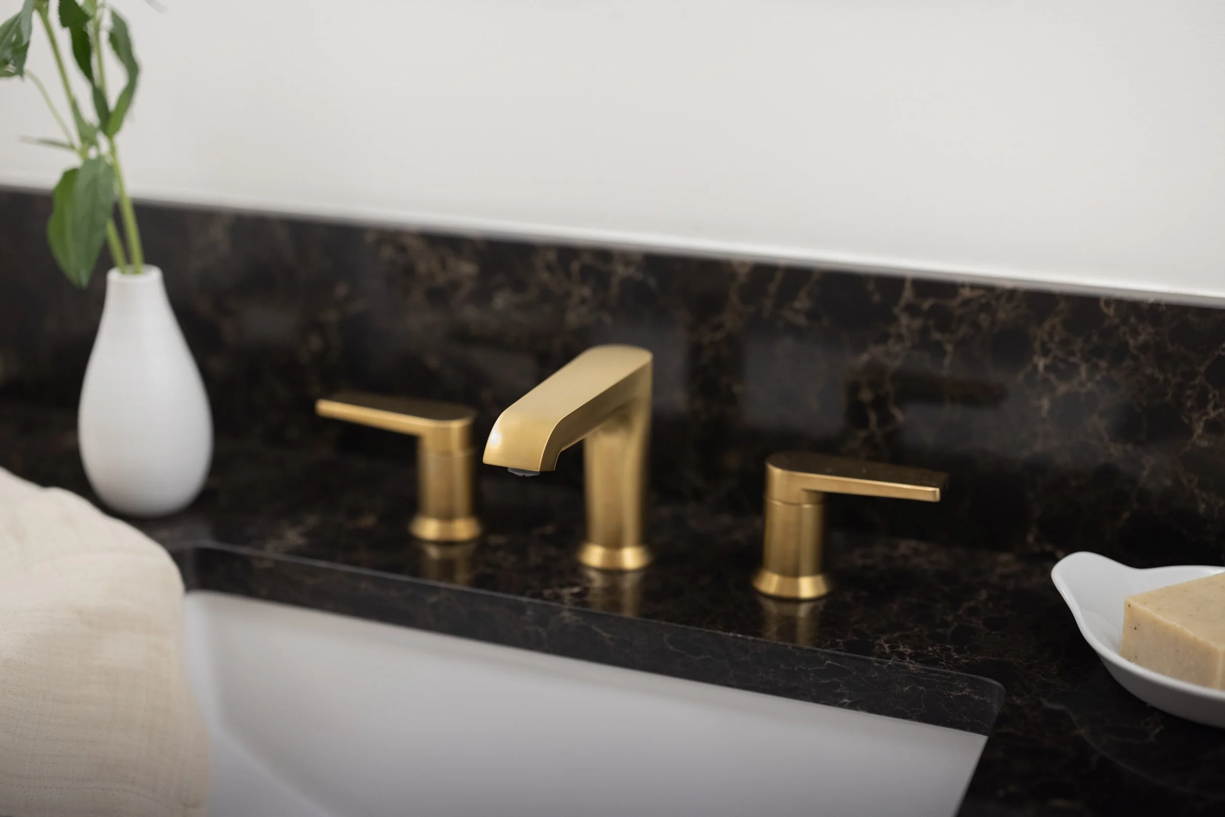 modern brass faucet and black quartz counters
