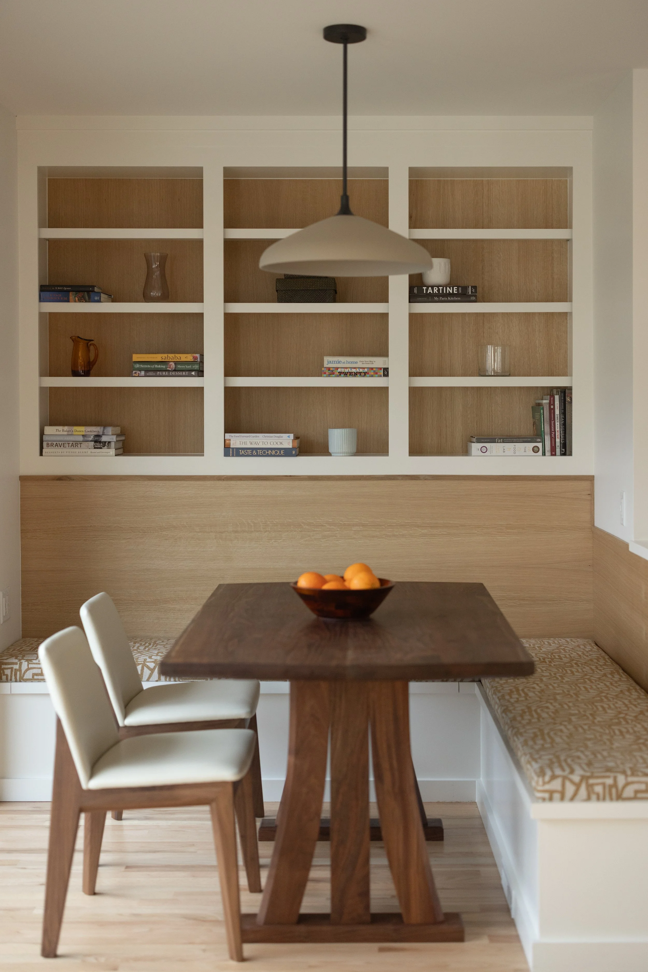 Modern dining nook with banquette seating and open shelving
