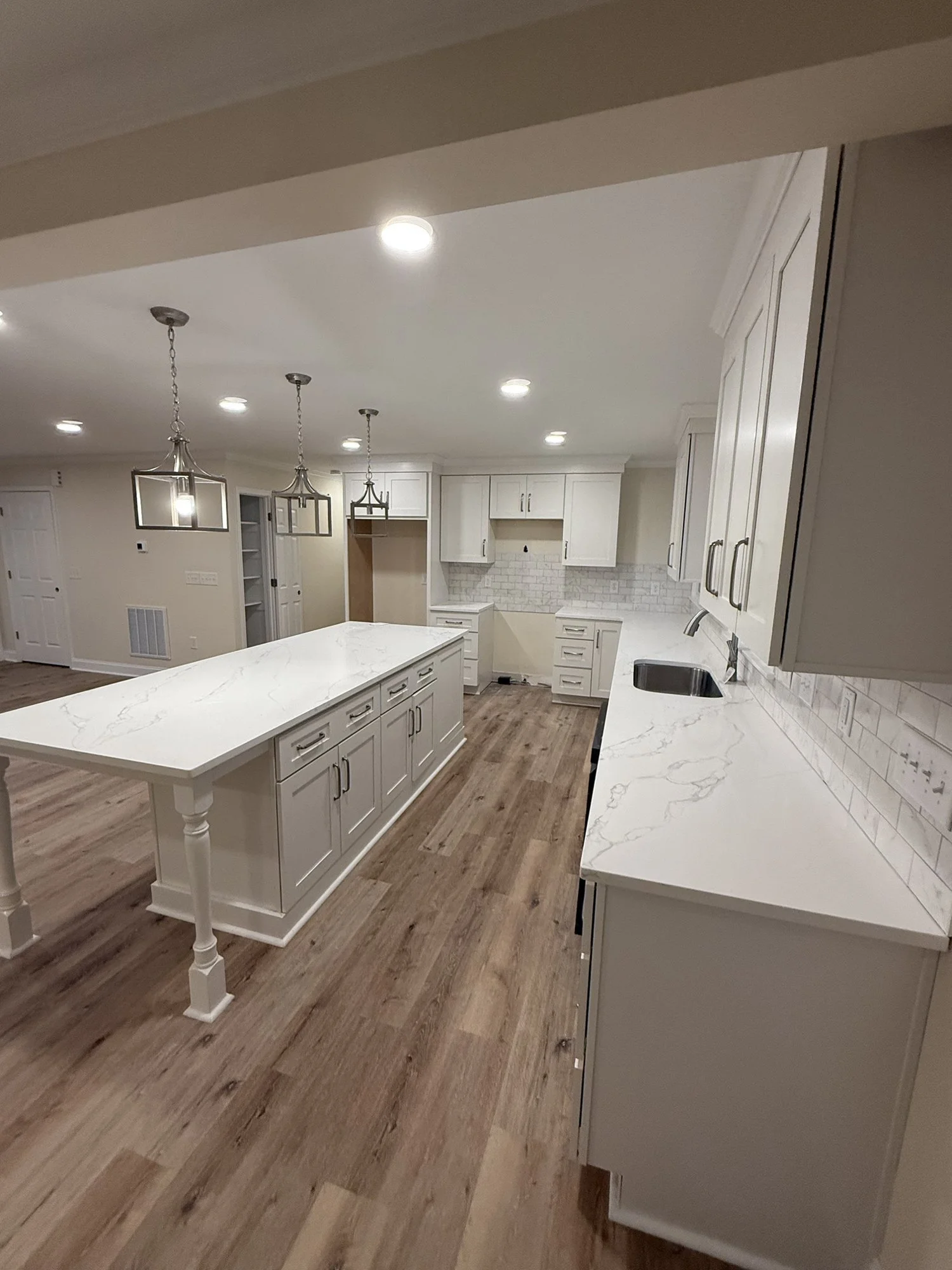 Kitchen remodel: island detail with pendant lights and a subway-tile backsplash.