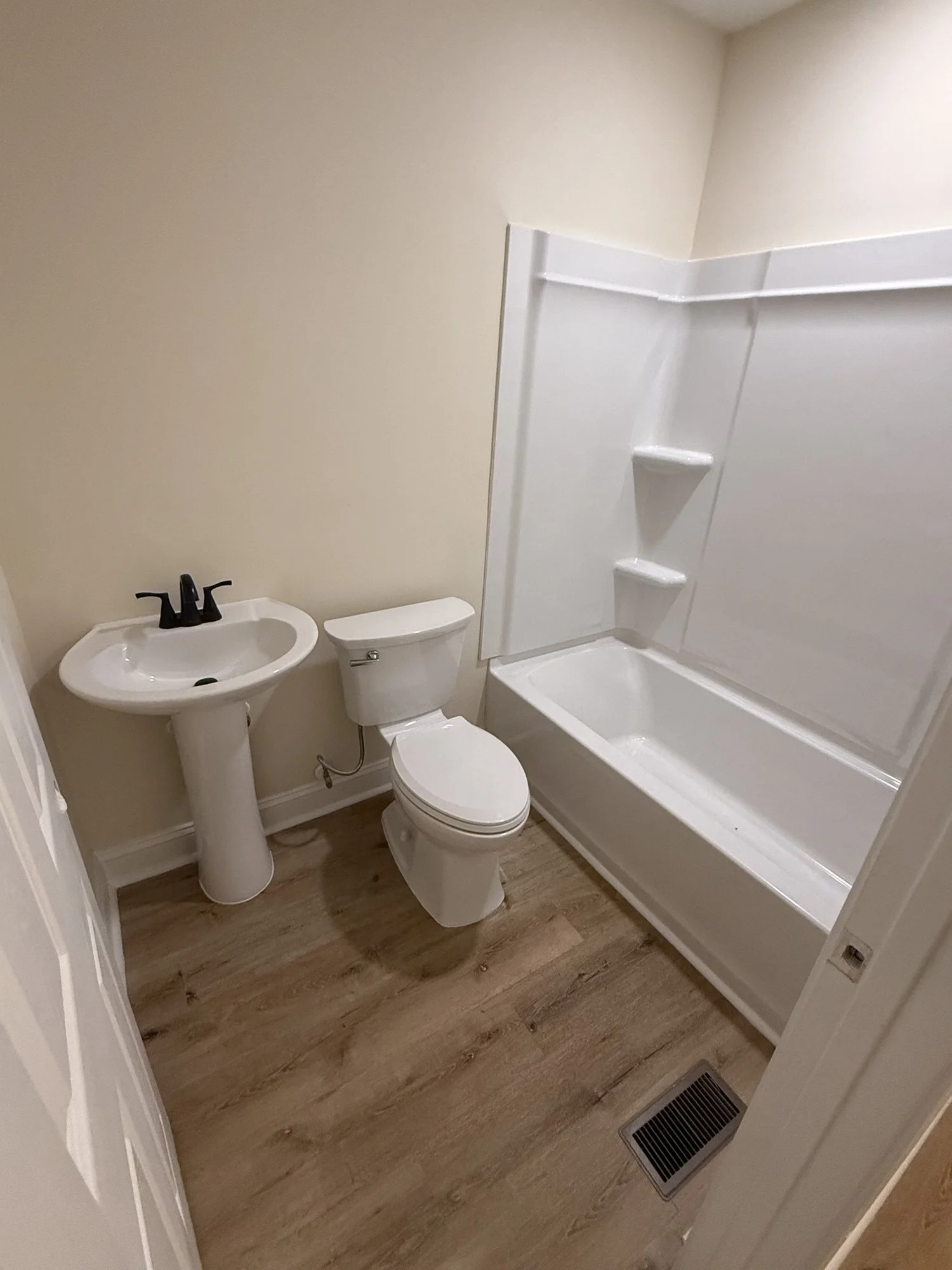 Bathroom remodel: pedestal sink, new tub and shower surround, fixtures and flooring.