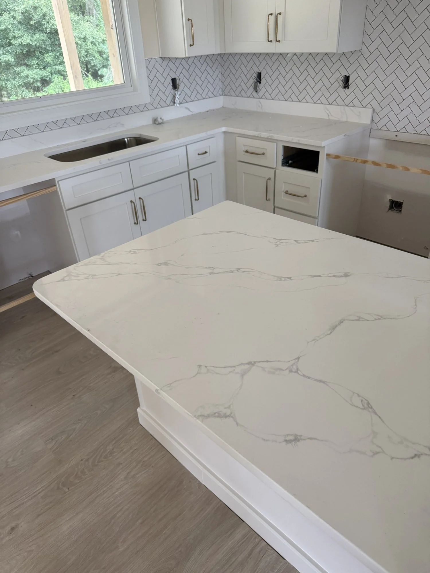 In progress: countertops and herringbone backsplash installed, finish work still under way.