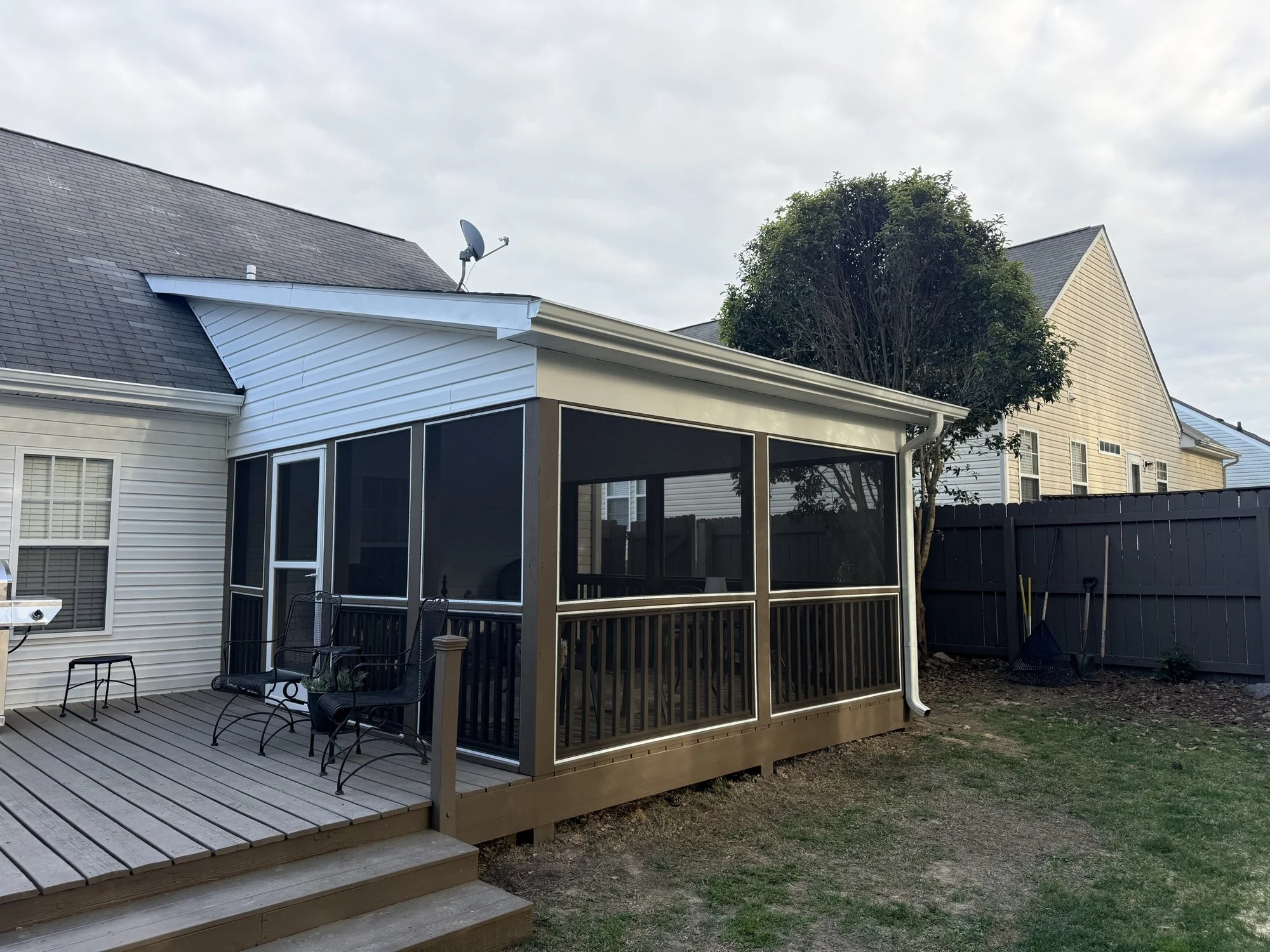 Screened porch addition with a metal roof and an open deck alongside it.