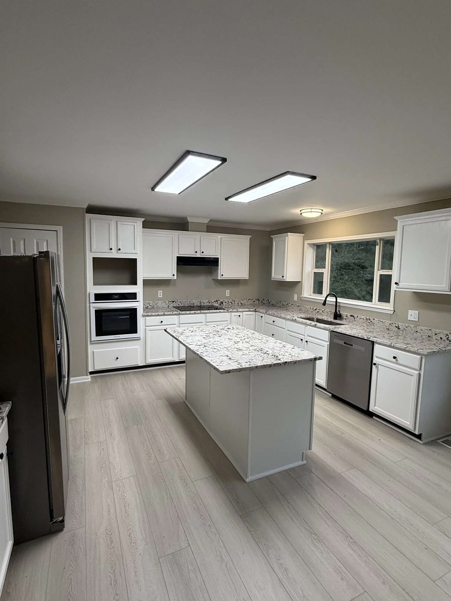 Kitchen remodel: island with seating, new cabinets, countertops and flooring.