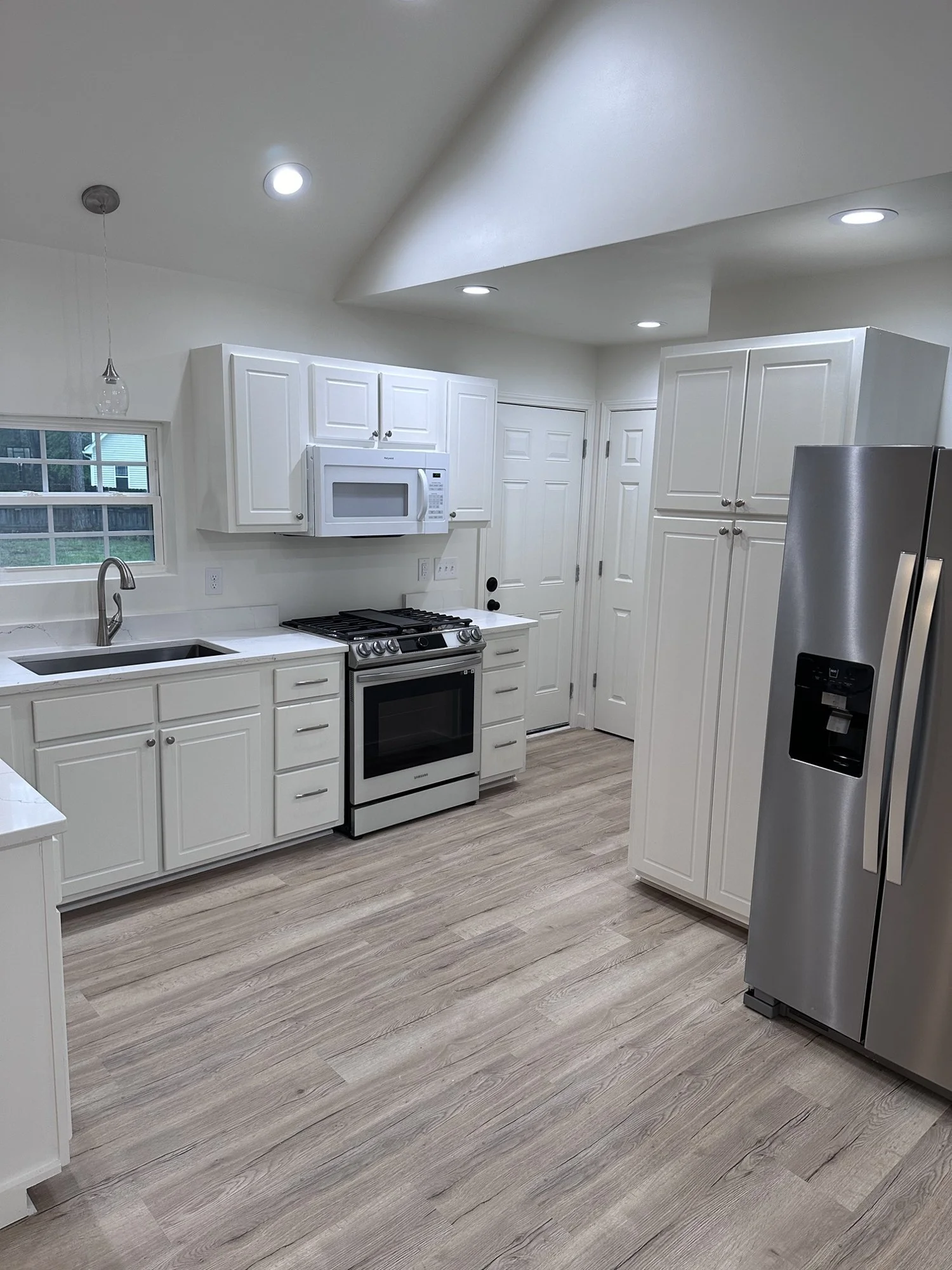 Kitchen remodel: white shaker cabinets, gas range and stainless appliances.