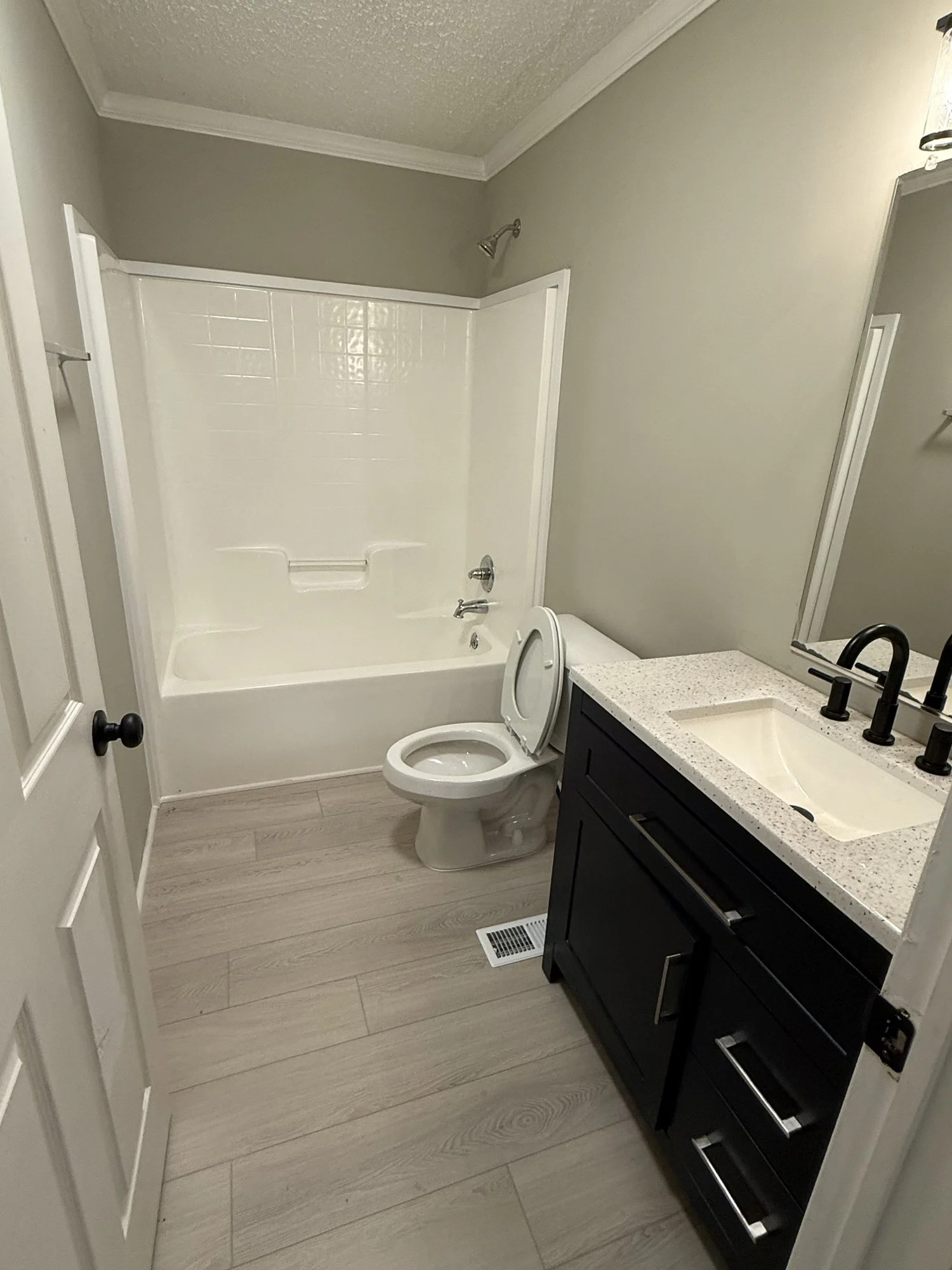 Bathroom remodel: new tub and shower surround, vanity, fixtures and plank flooring.