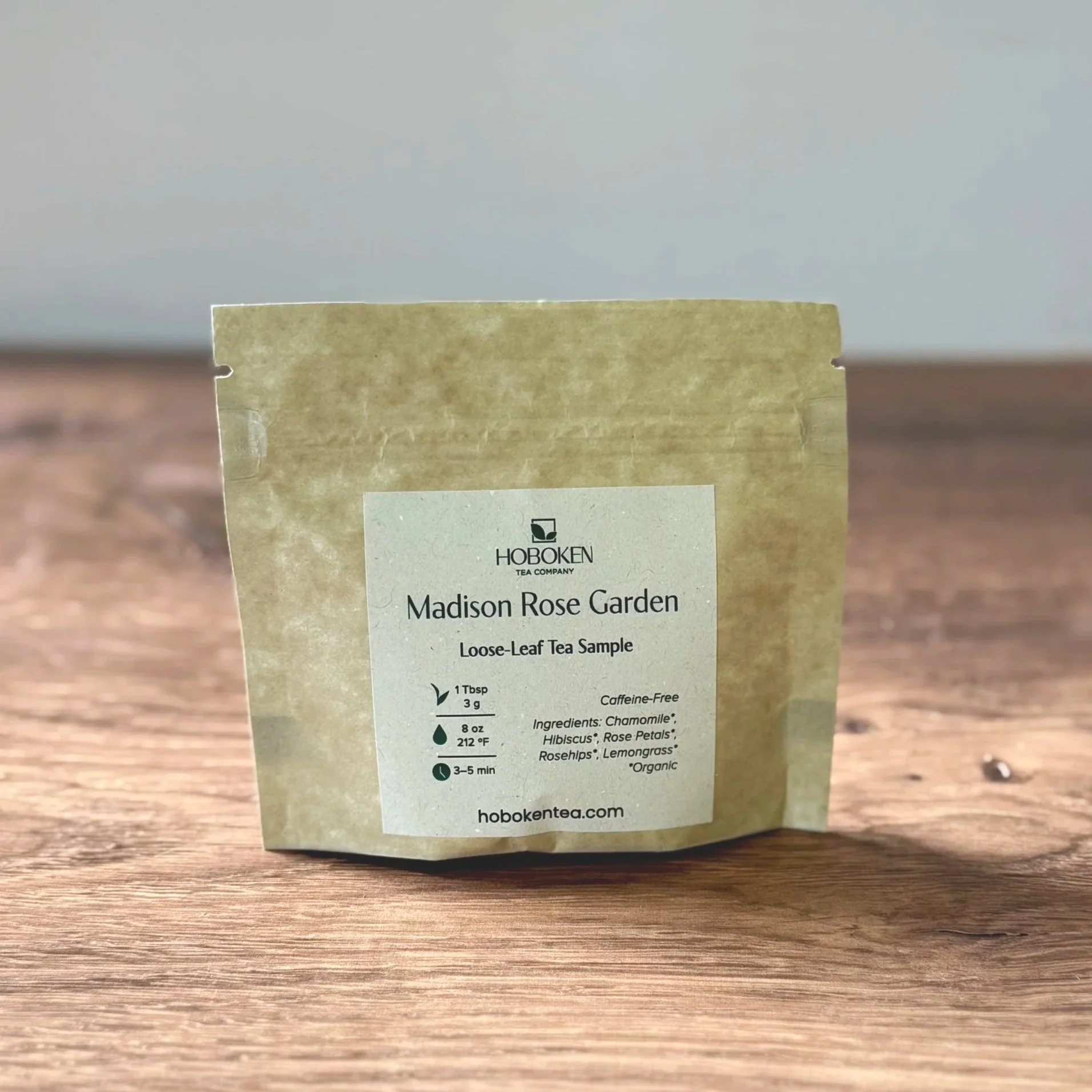 a small kraft brown paper packet of loose leaf tea on a wood table