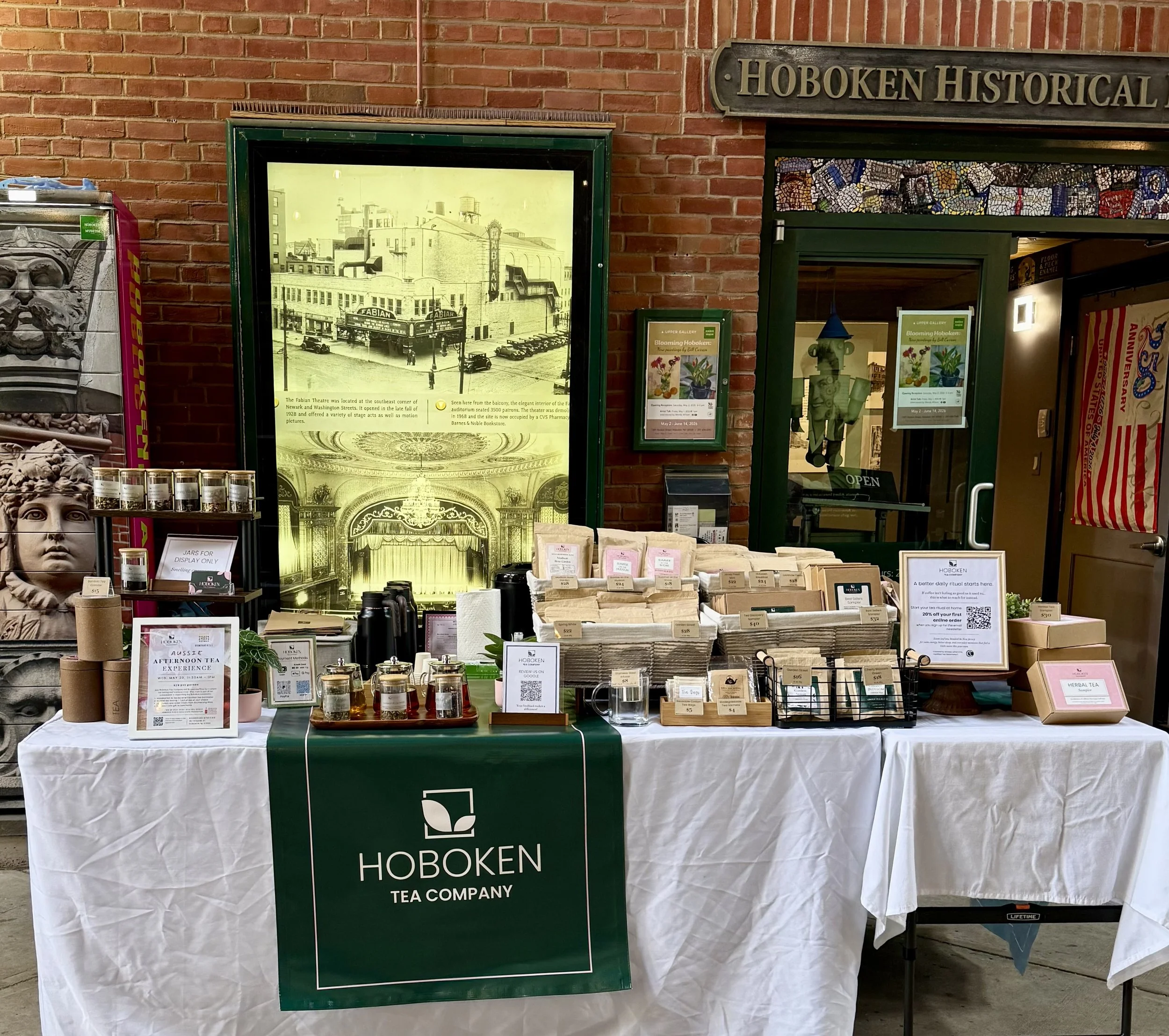 a vendor table with an assortment of packaged loose leaf teas and the Hoboken Tea Company logo
