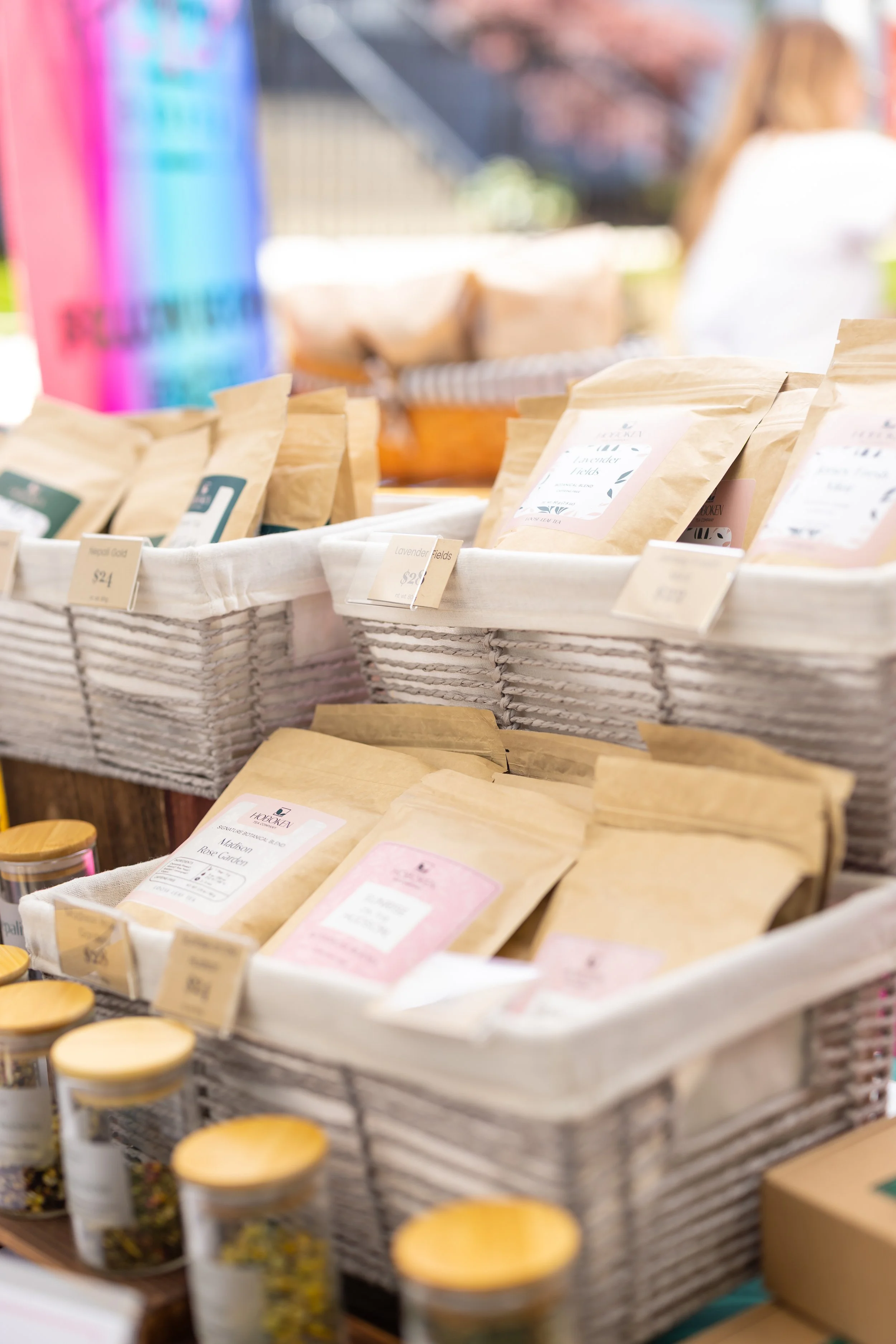 a market table displaying packets of tea in baskets
