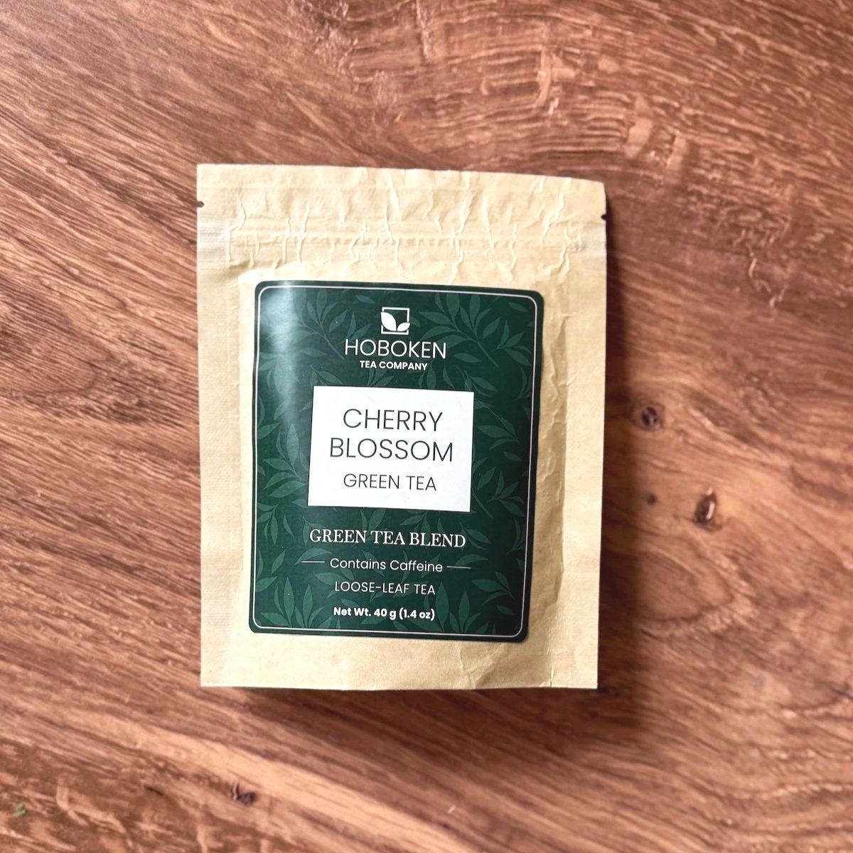 brown kraft paper package of cherry blossom green tea on a wood table
