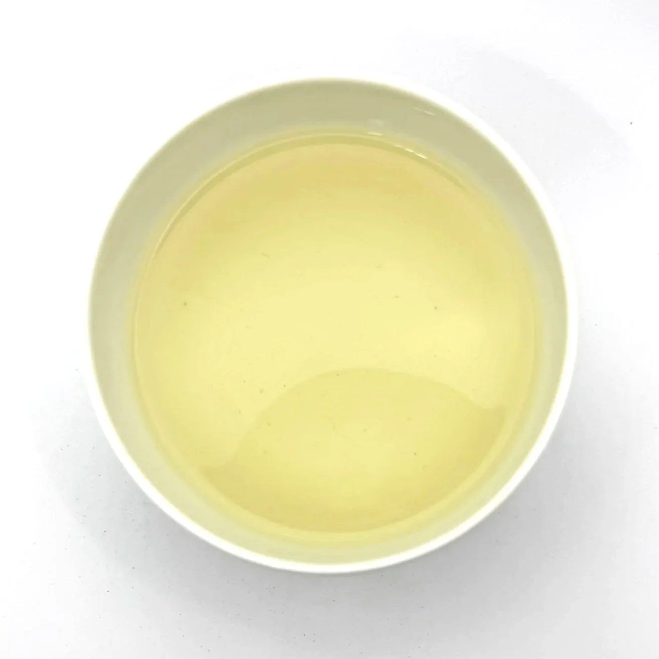 a white bowl of green tea on a white background