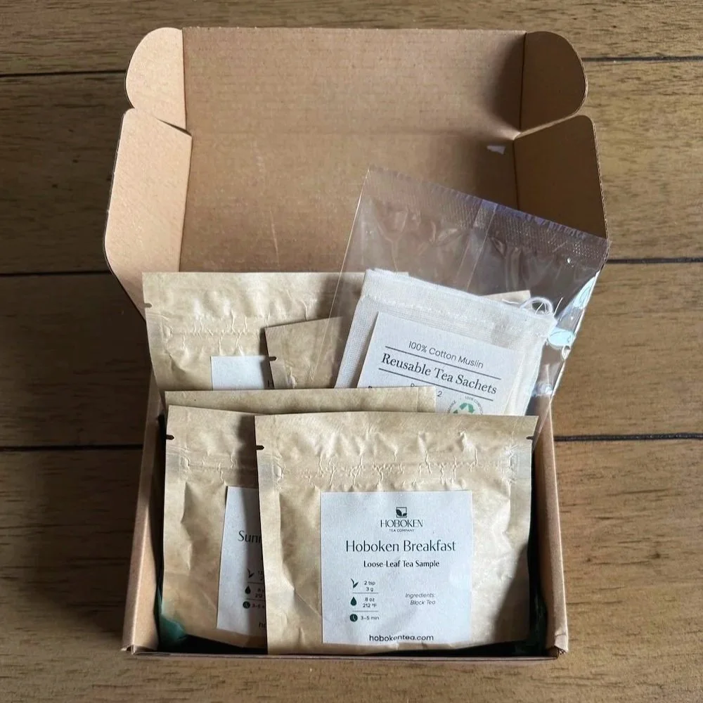 An open box containing several small packets of loose leaf tea