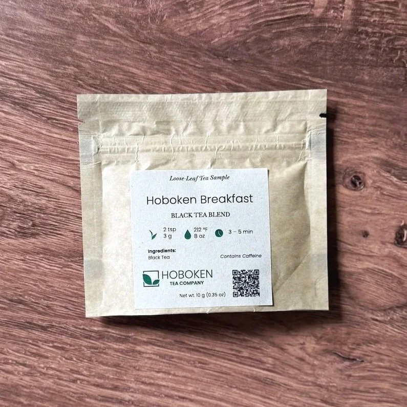 A small paper packet of Hoboken Breakfast loose leaf black tea on a wood surface