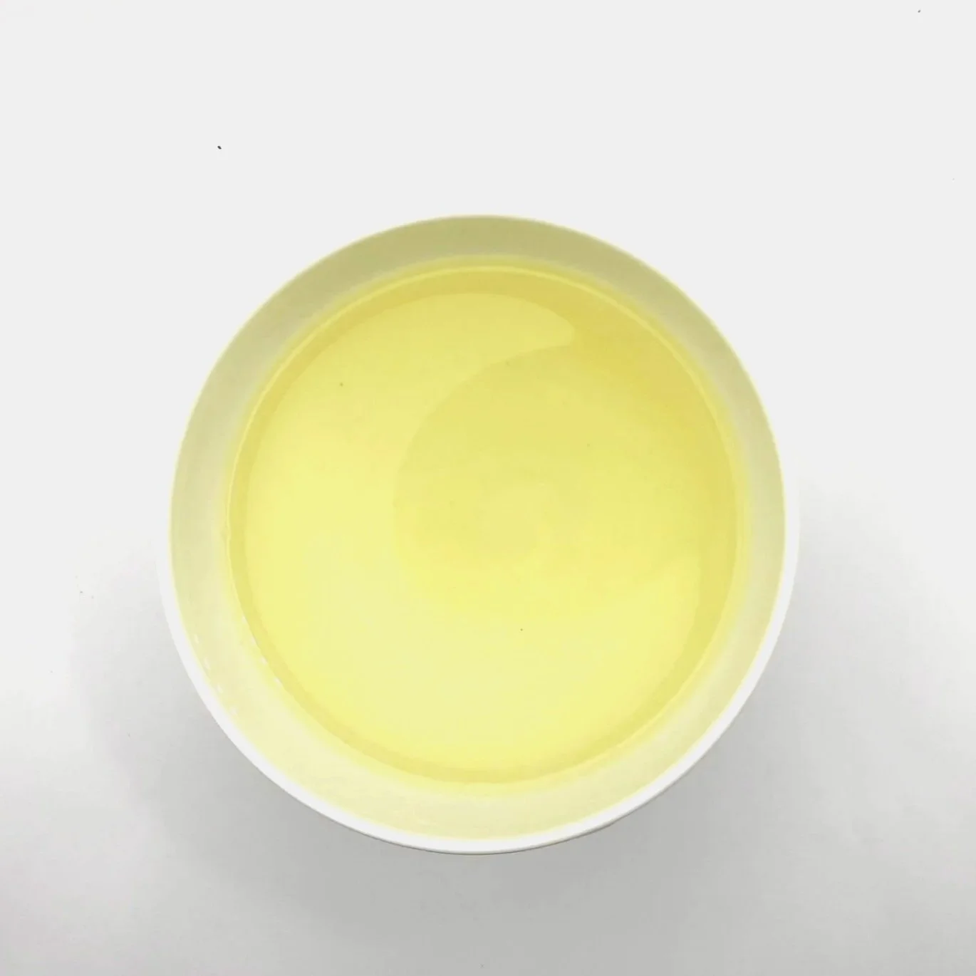 a white bowl of green tea on a white background