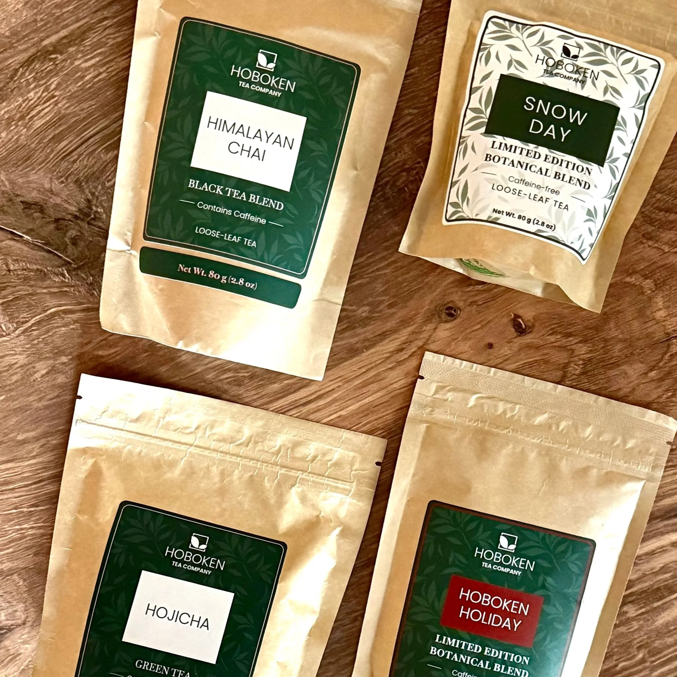 four packets of loose leaf tea with Hoboken Tea Company branding on a wood table