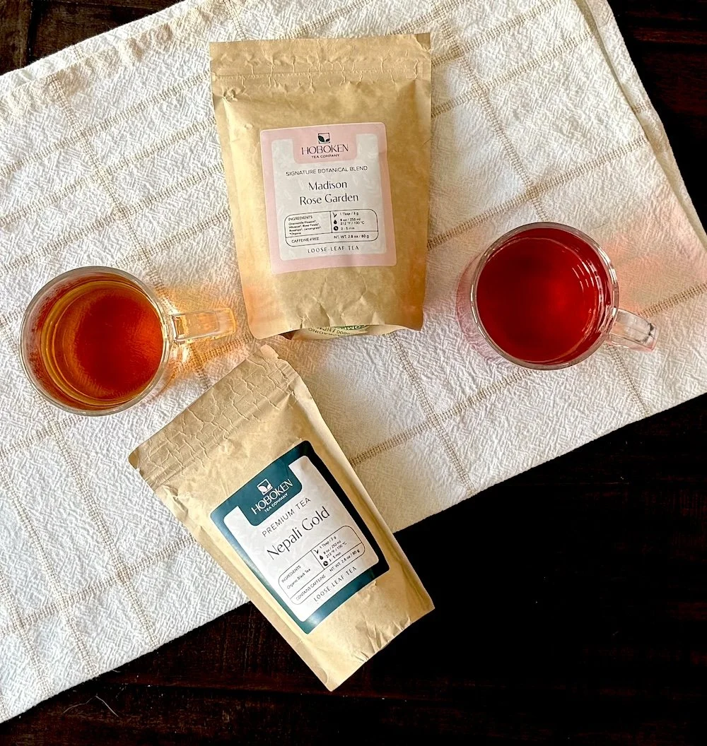 two cups of tea next to packets of Hoboken Tea Company loose leaf tea on a table