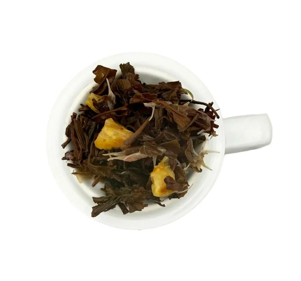Black leaves with bergamot peel after infusion and straining on a white background