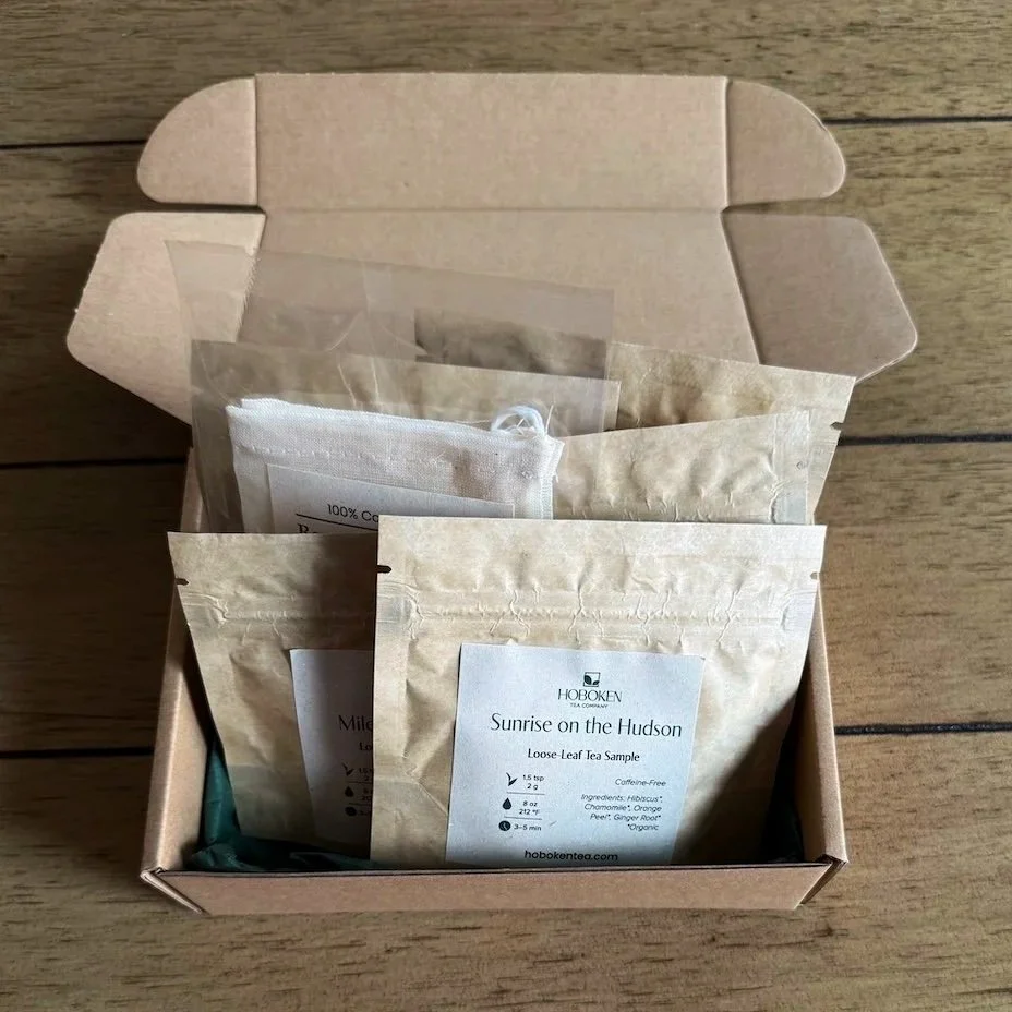 an open box containing several small packets of loose leaf tea