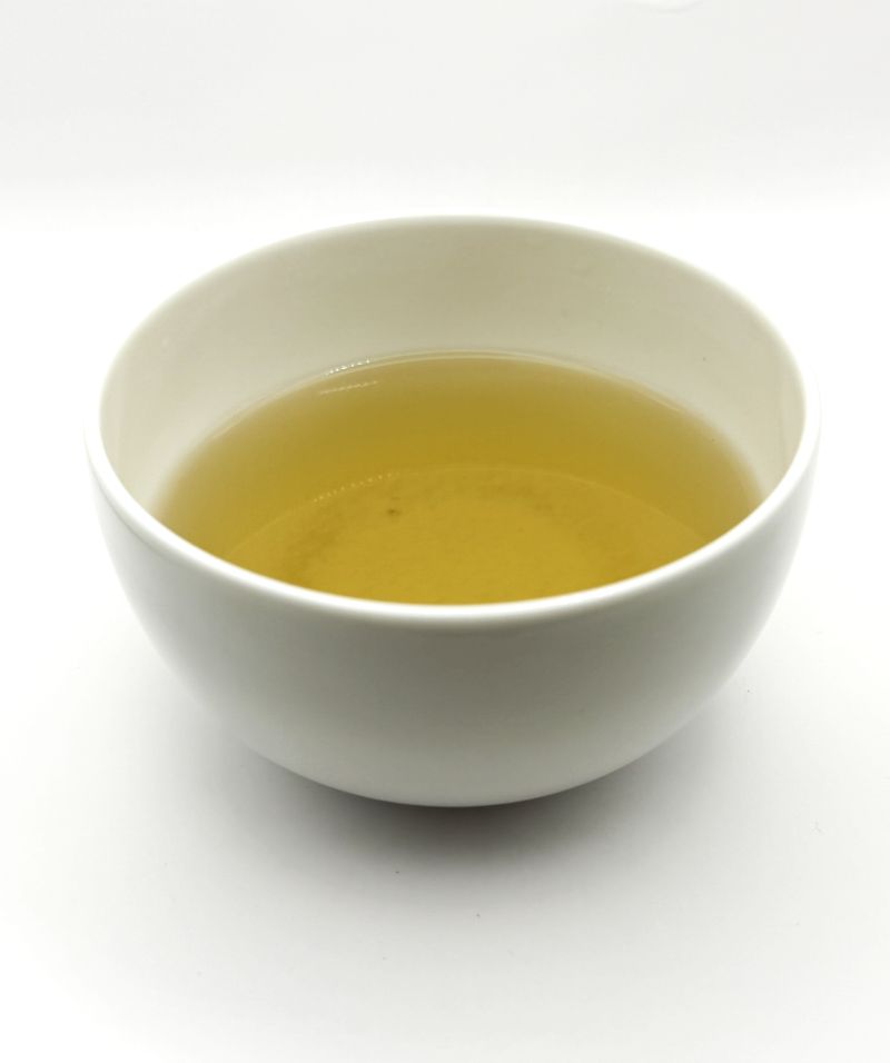 a white bowl of organic herbal tea on a white background