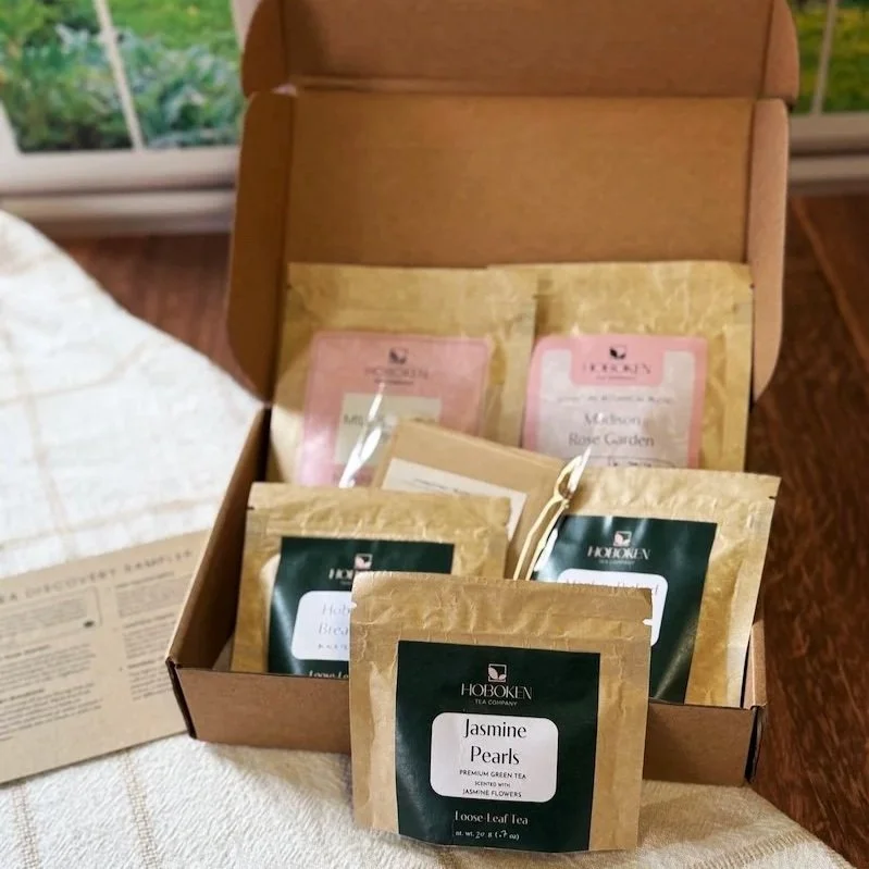 an open loose leaf tea sampler box in front of a window