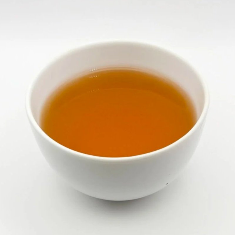A white bowl of black Liberty Grey tea on a white background