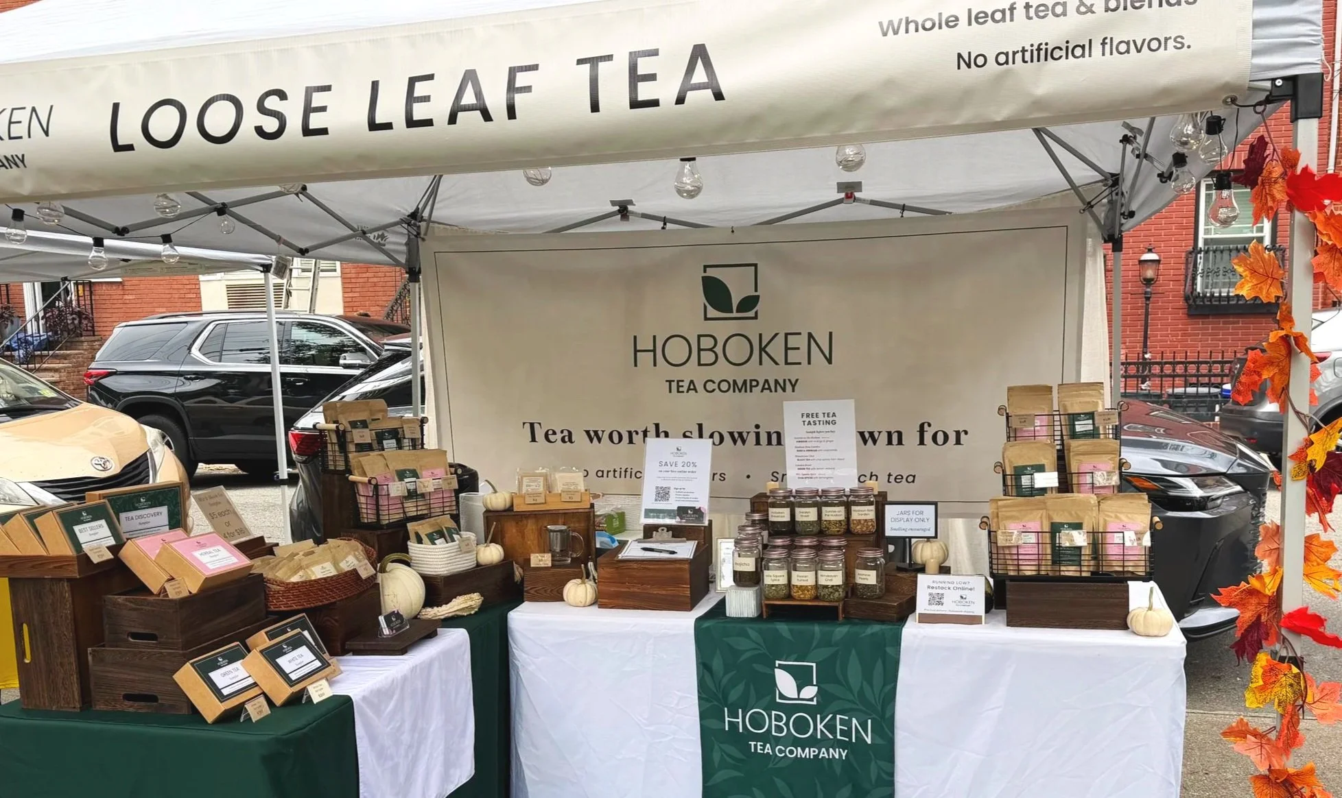 a farmers market table display featuring the Hoboken Tea Company logo
