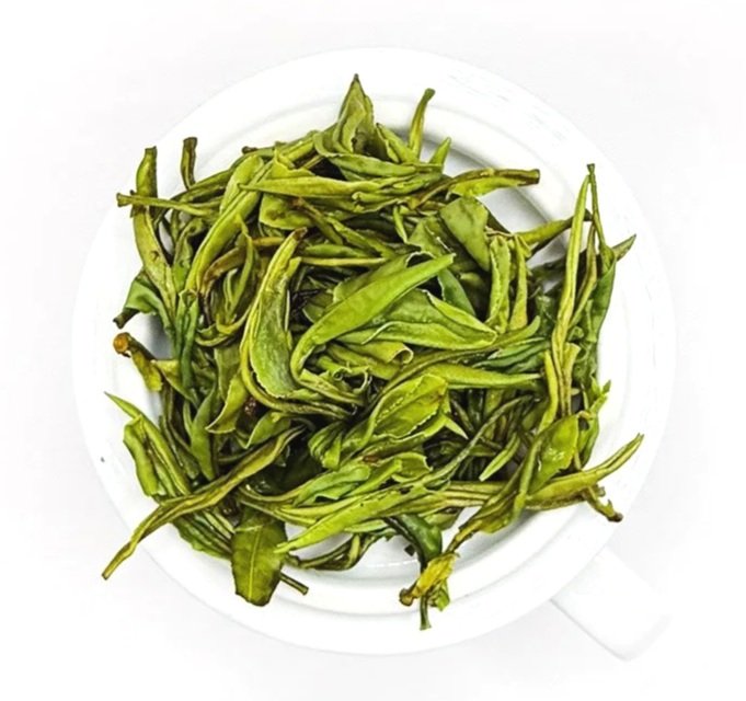 Close up of wet green tea leaves on a white background