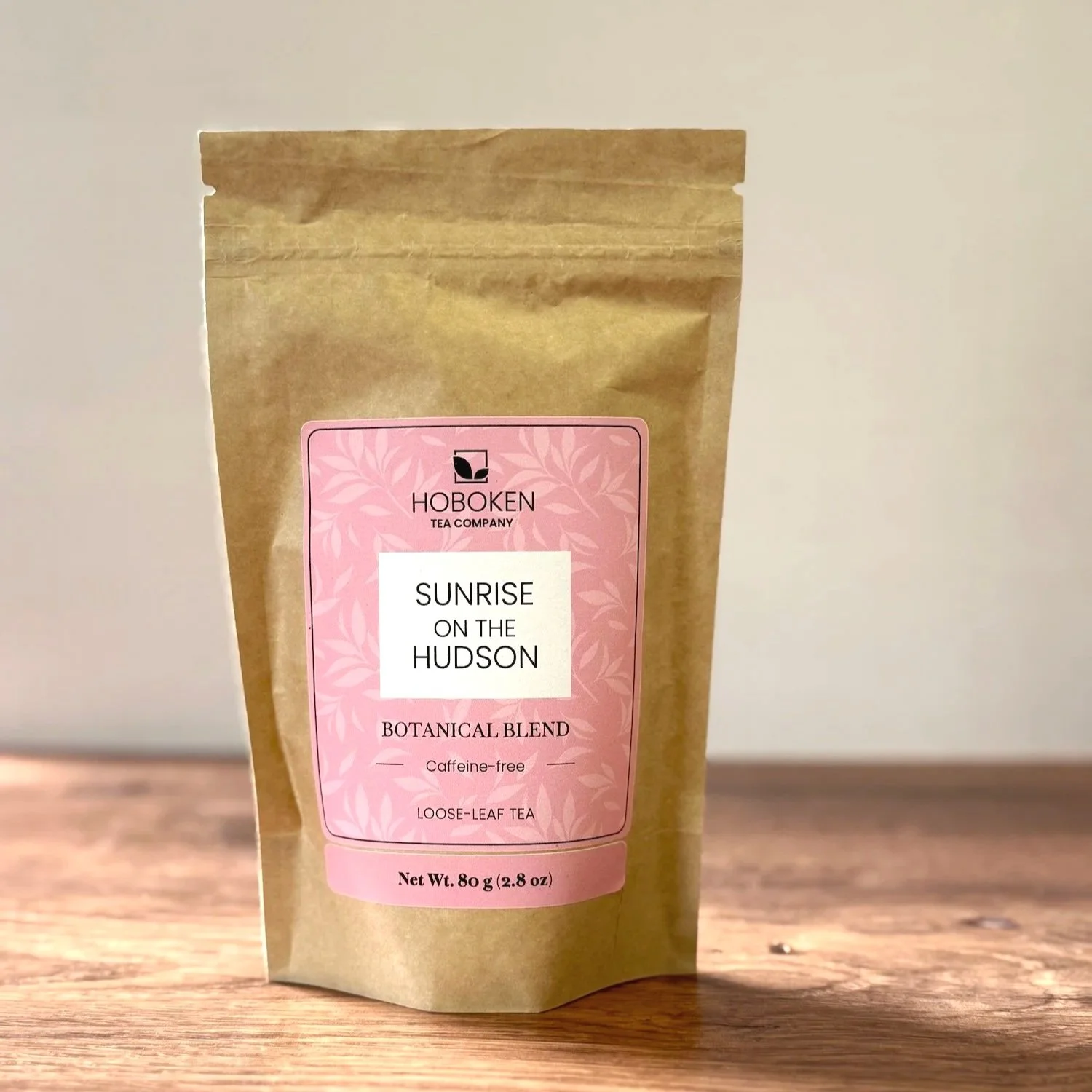 a large brown paper pouch of Sunrise on the Hudson herbal tea with a pink label on a white background