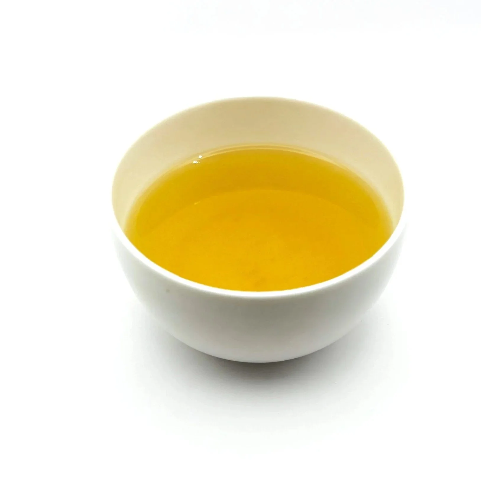 a white bowl of organic turmeric ginger herbal tea on a white background