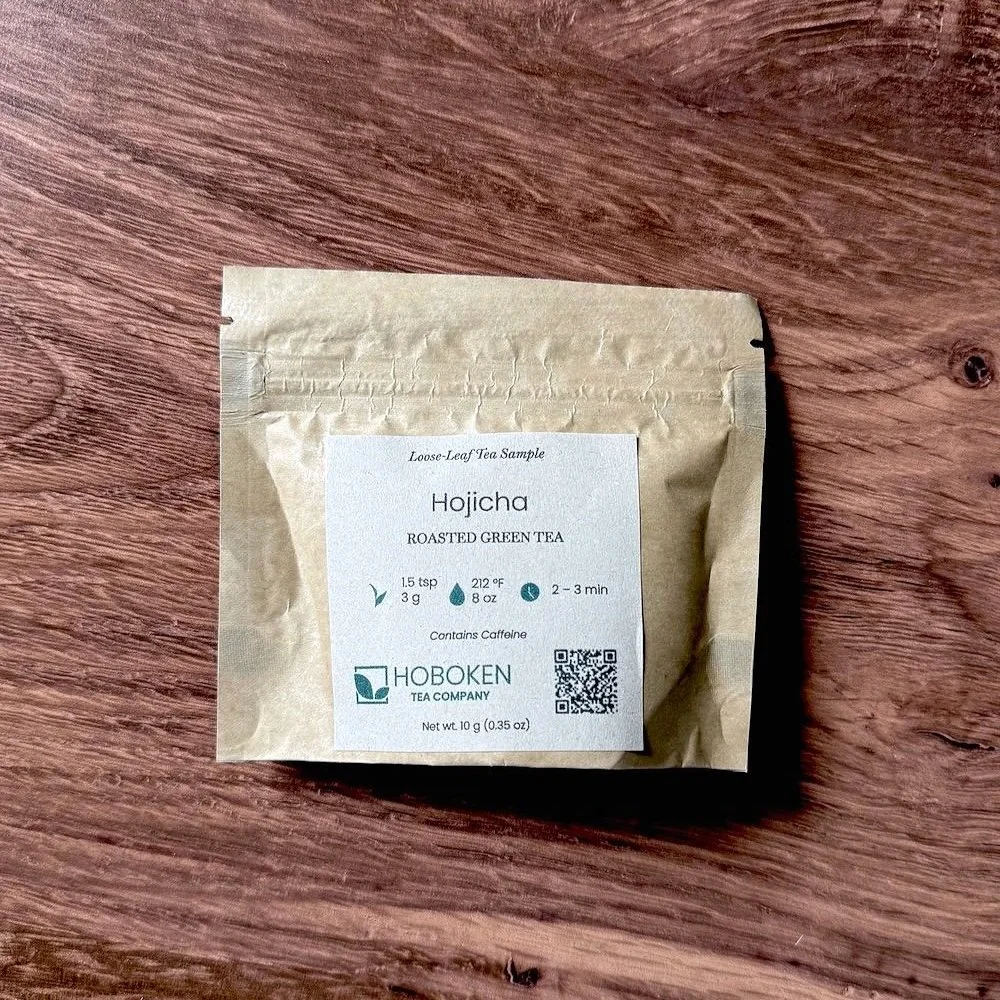 small brown paper packet of Hojicha roasted green tea on a wood table