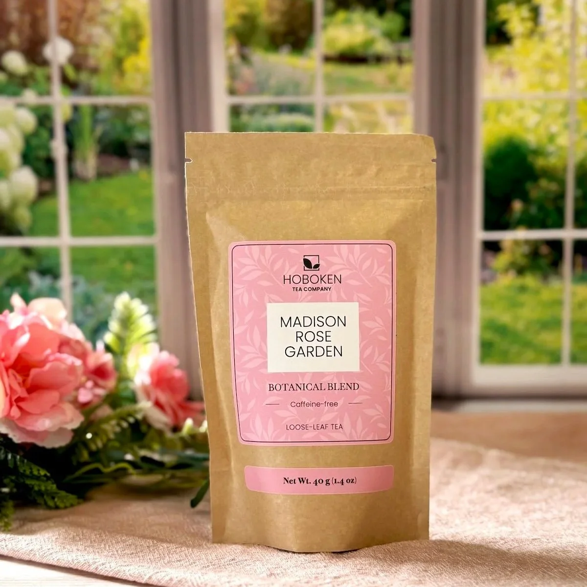 a package of Madison Rose Garden loose leaf tea on a tray next to a bunch of flowers in front of a sunny window