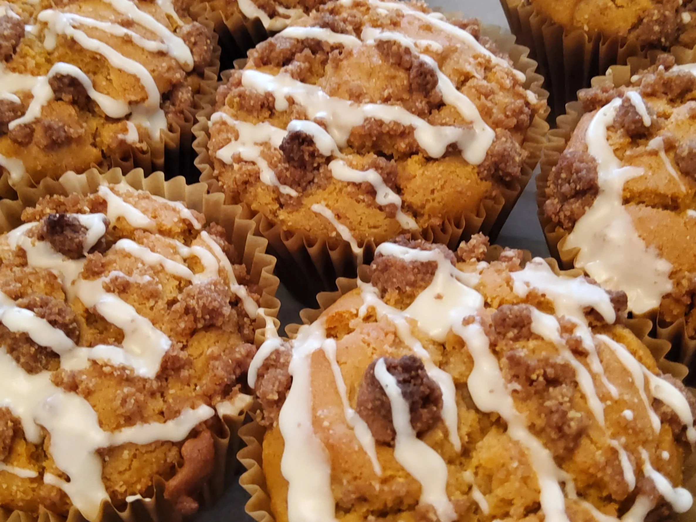 plant-based and gluten free sweet potato muffins topped with cinnamon sugar crumble and maple drizzle