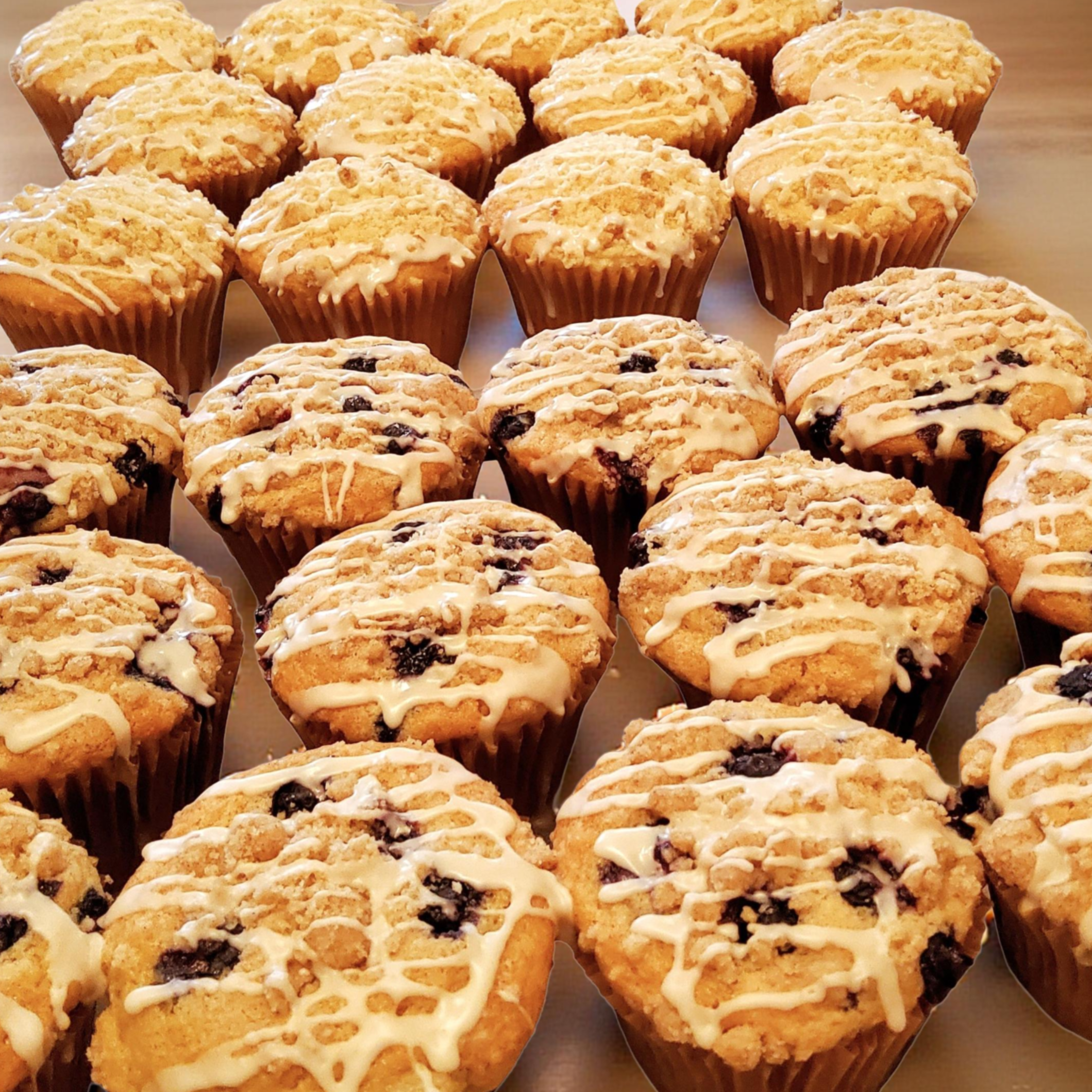plant-based blueberry and lemon muffins topped with sugar crumble and vanilla icing