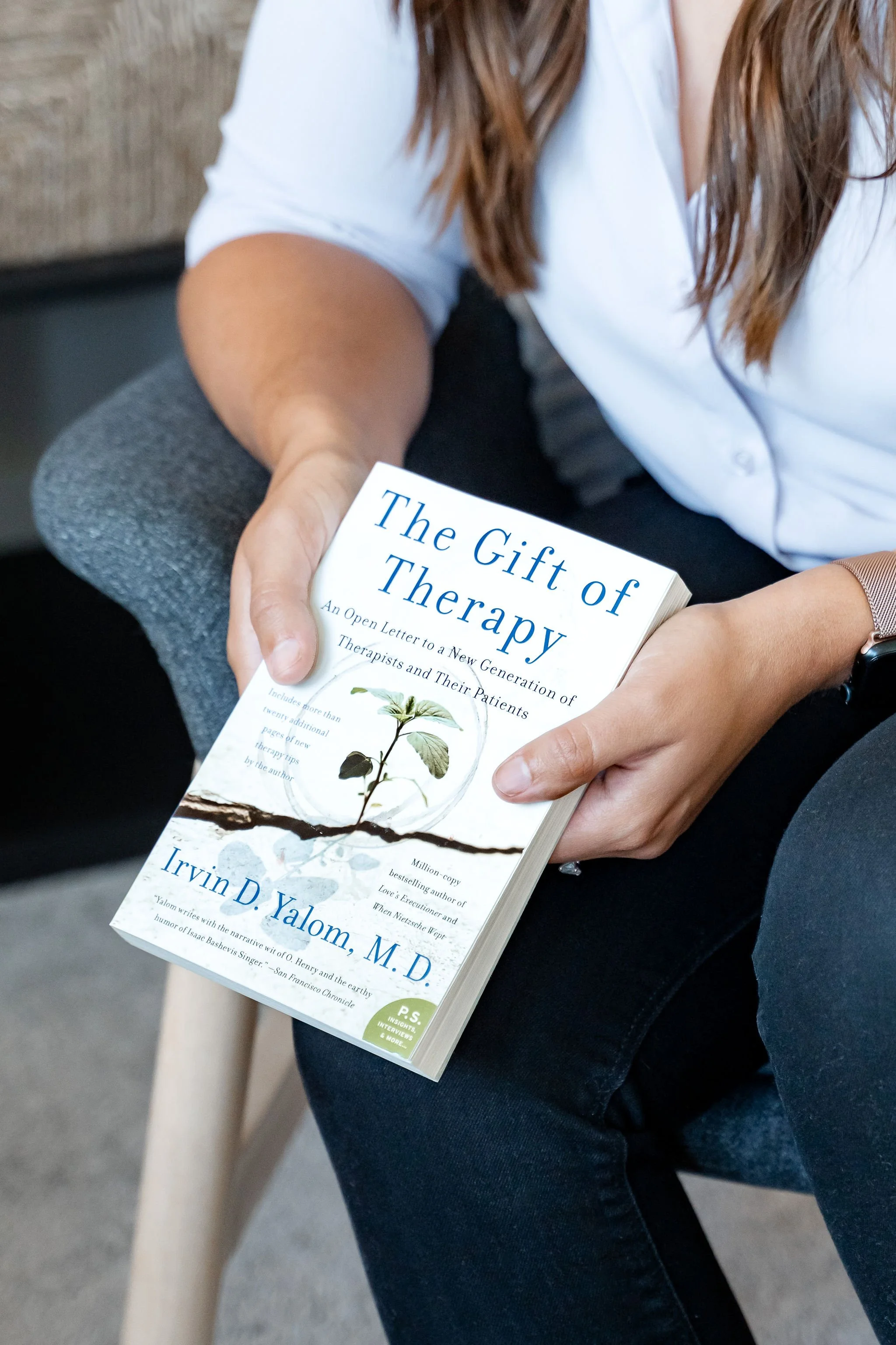 Person holding ‘The Gift of Therapy’ book during a reflective moment in a counselling session.