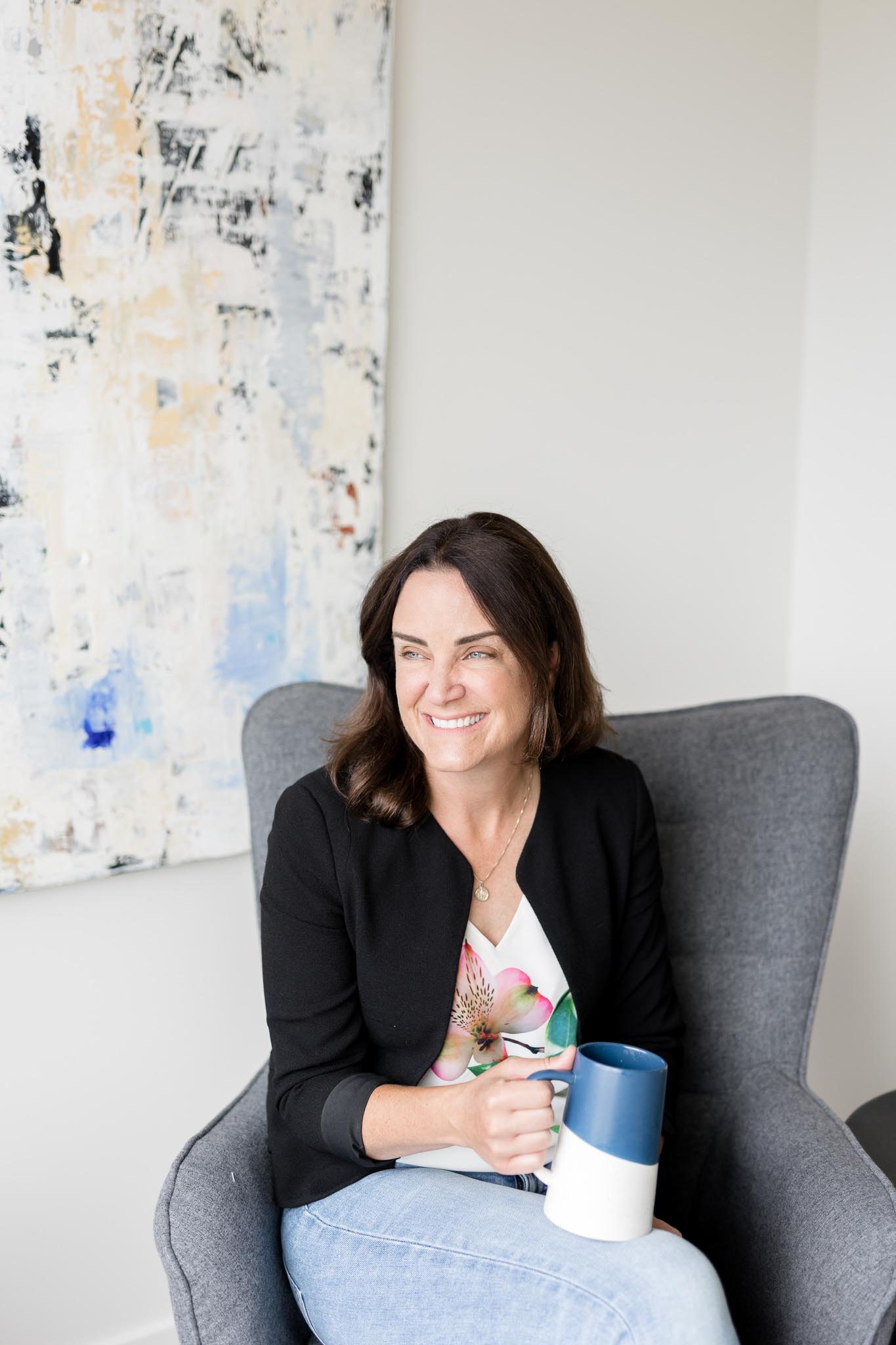 Therapist in a Calgary office holding a mug and practicing mindfulness and presence