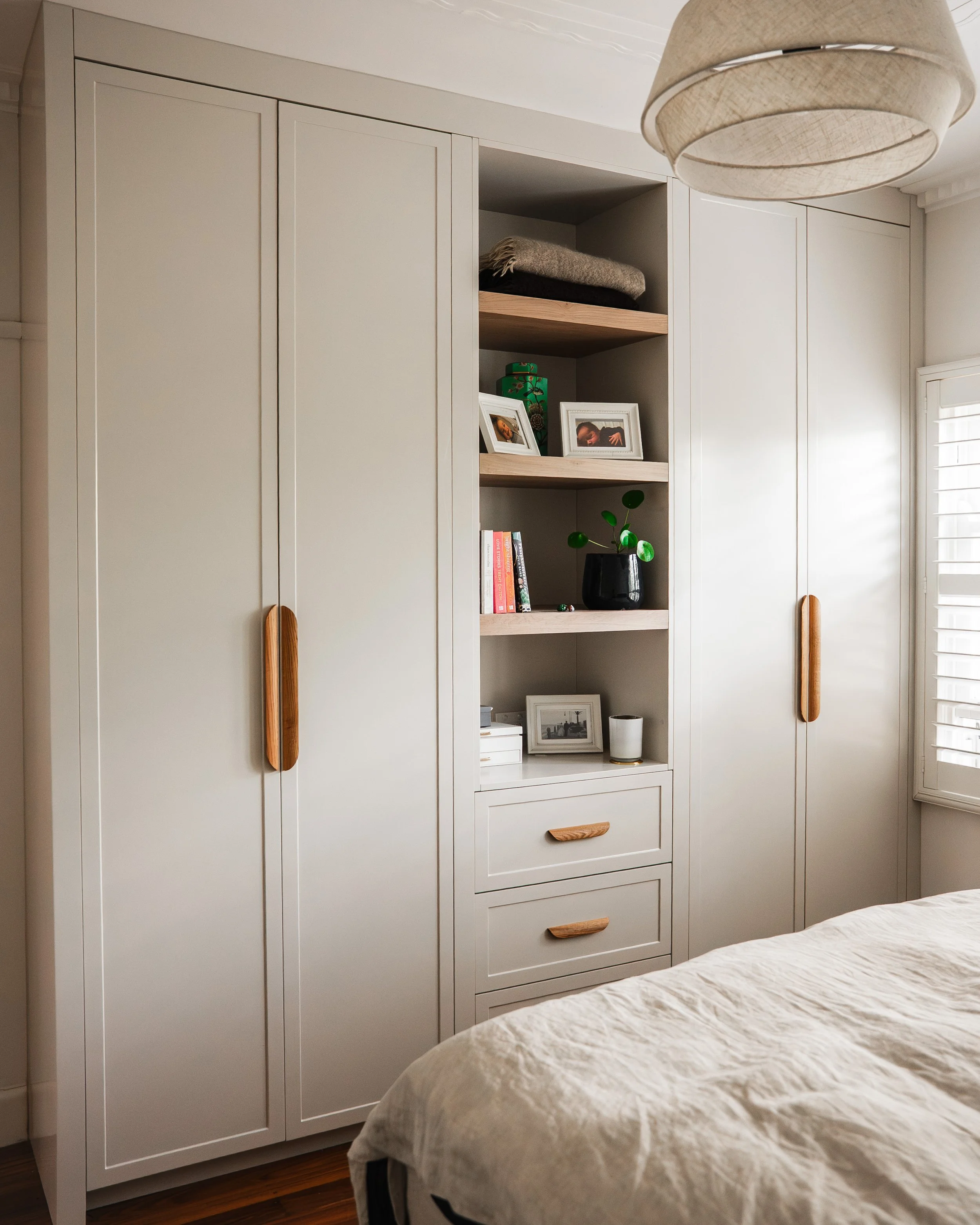 Bespoke bedroom wardrobe with timber handles and open shelving, Yarraville renovation by Lúrae Studio