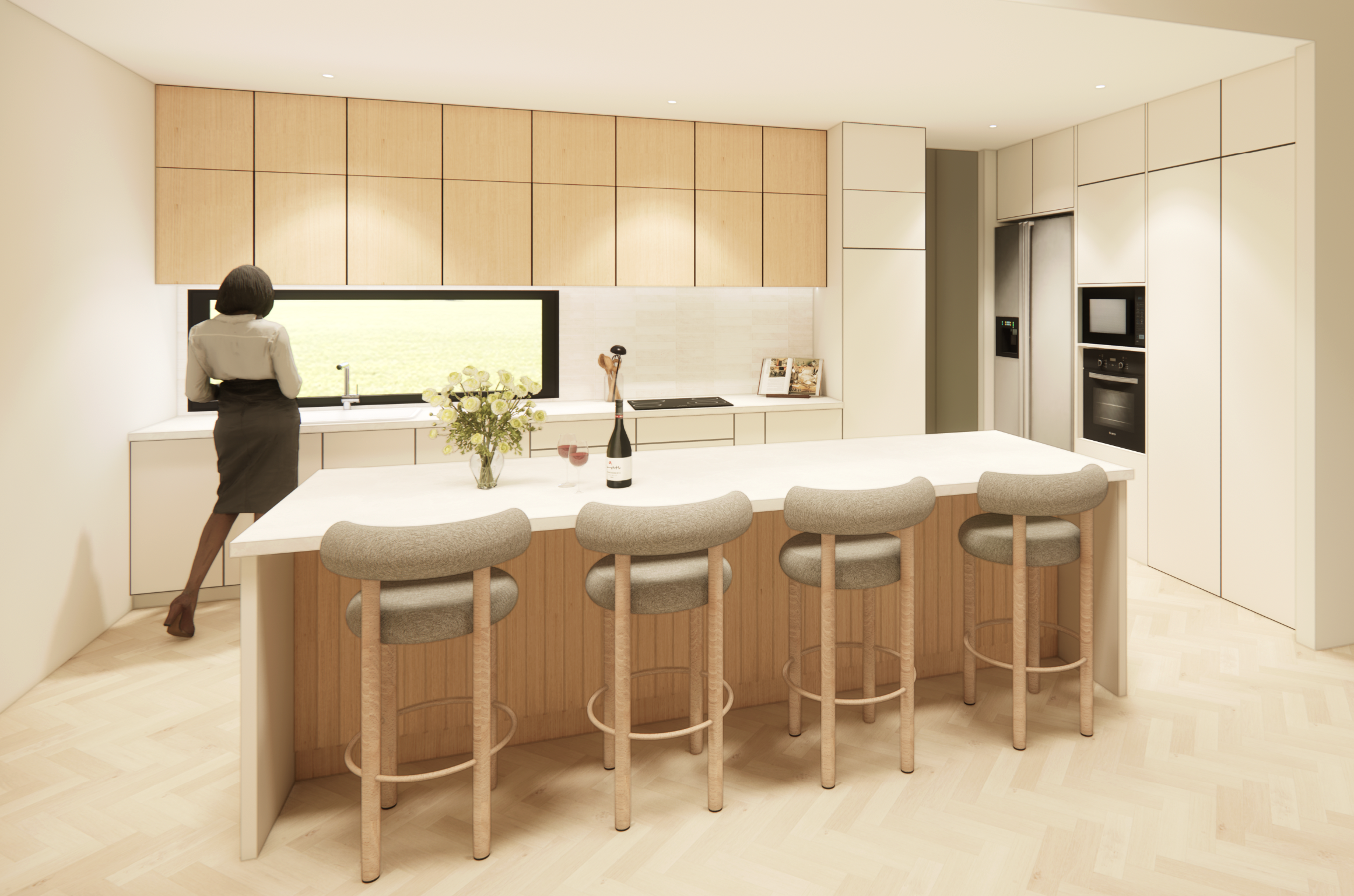 Modern kitchen with white and wood cabinetry, a large island with four beige upholstered stools, a bouquet of flowers, a bottle of wine, and two glasses, woman in professional attire standing at the sink.